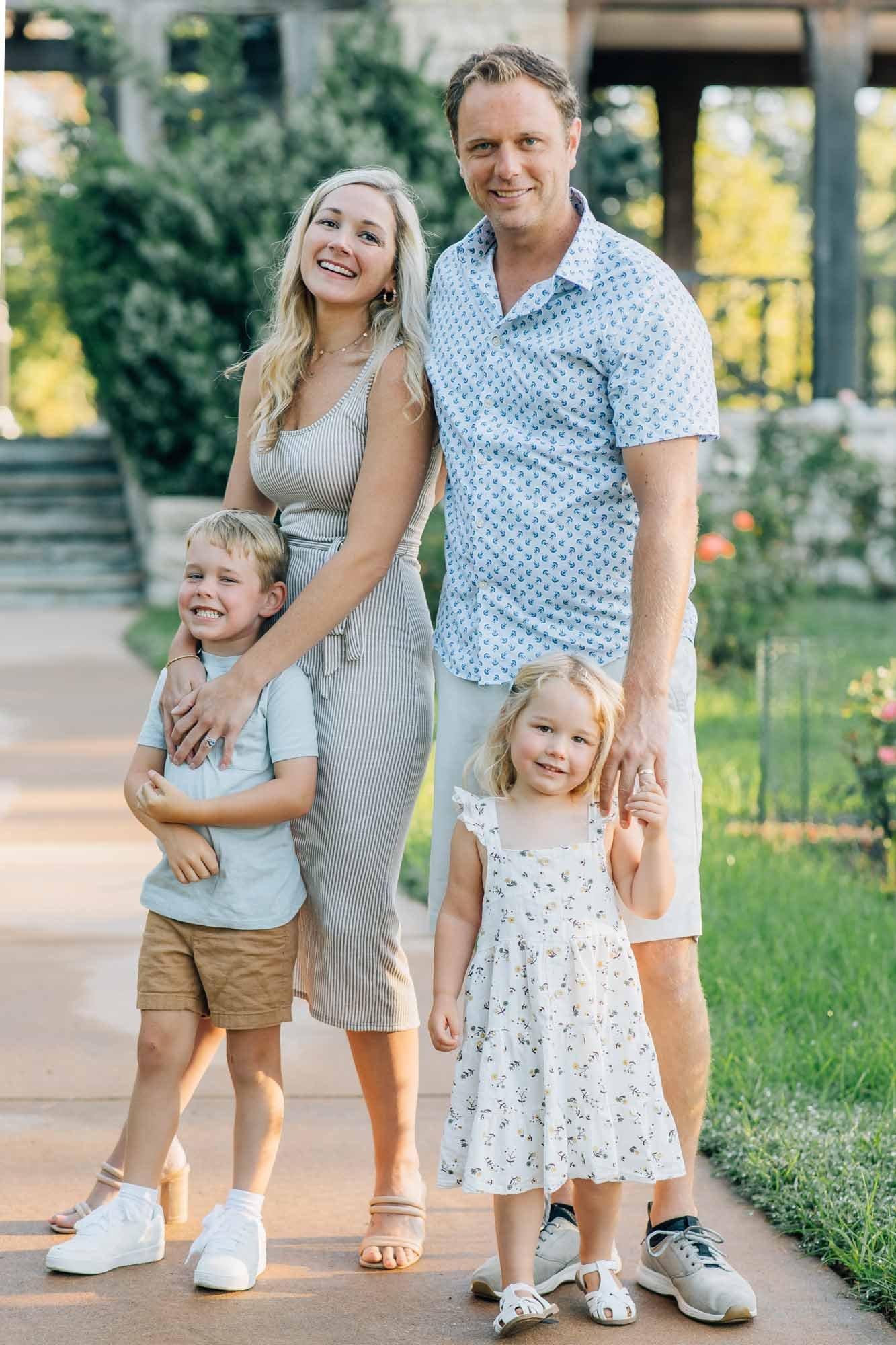 family of four posing on a path in a park