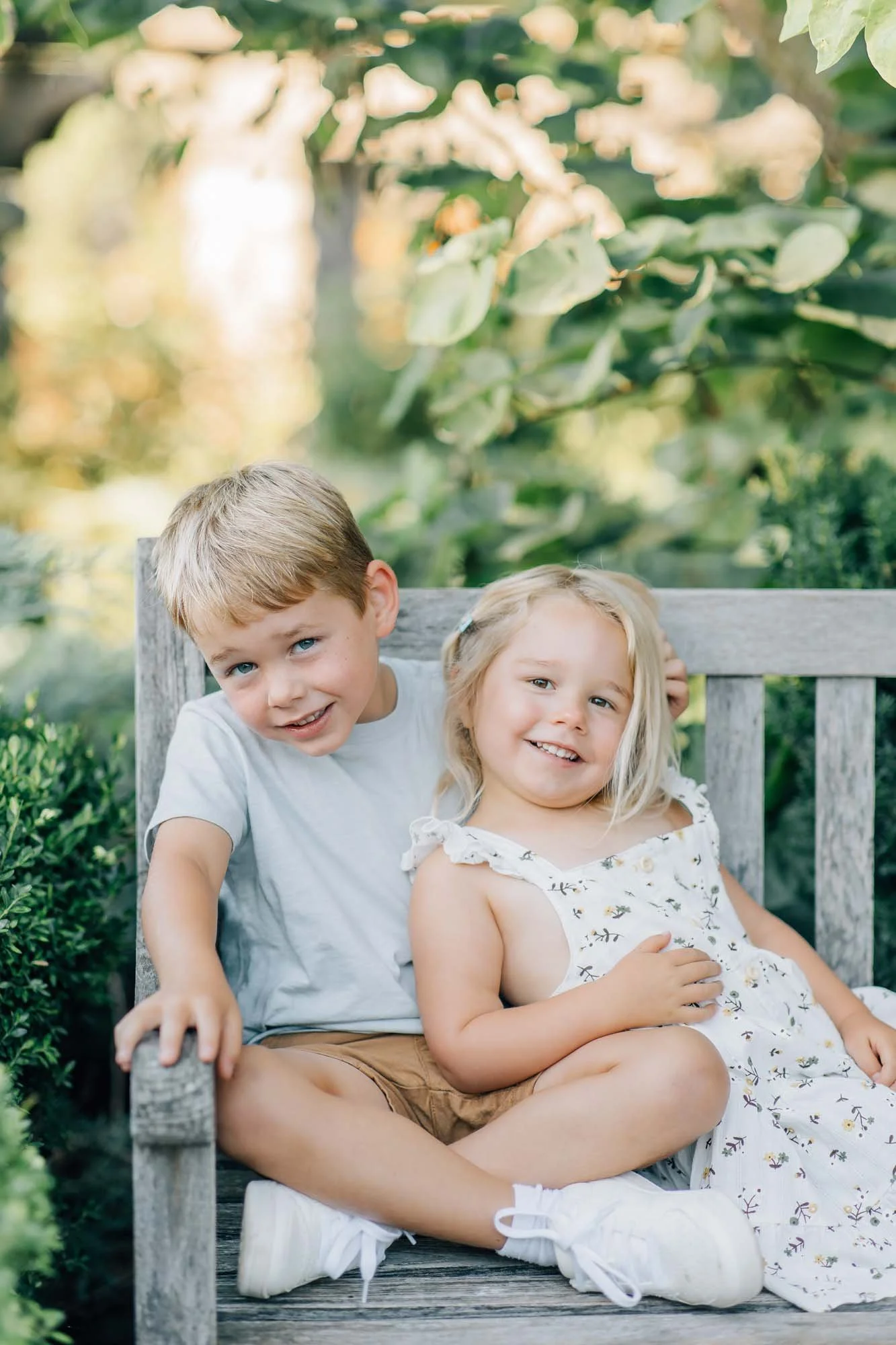 brother and sister portrait on a bench in the park