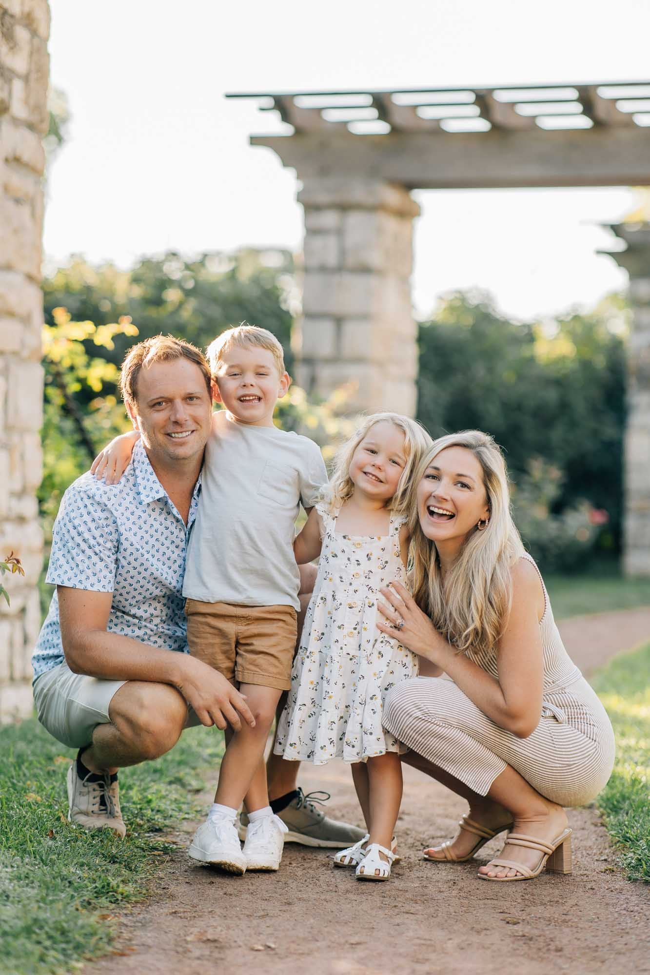 family of four posing near pillars