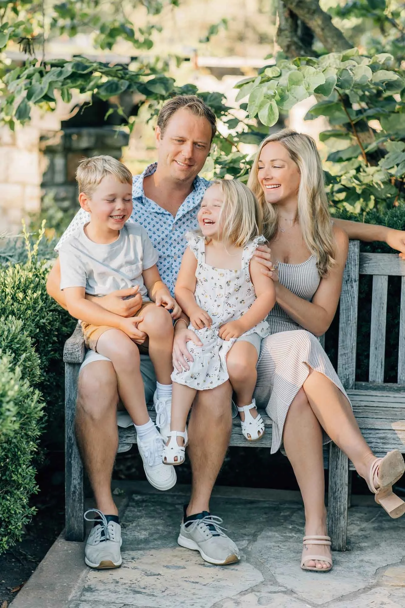 family of four sitting on a bench posing for photos