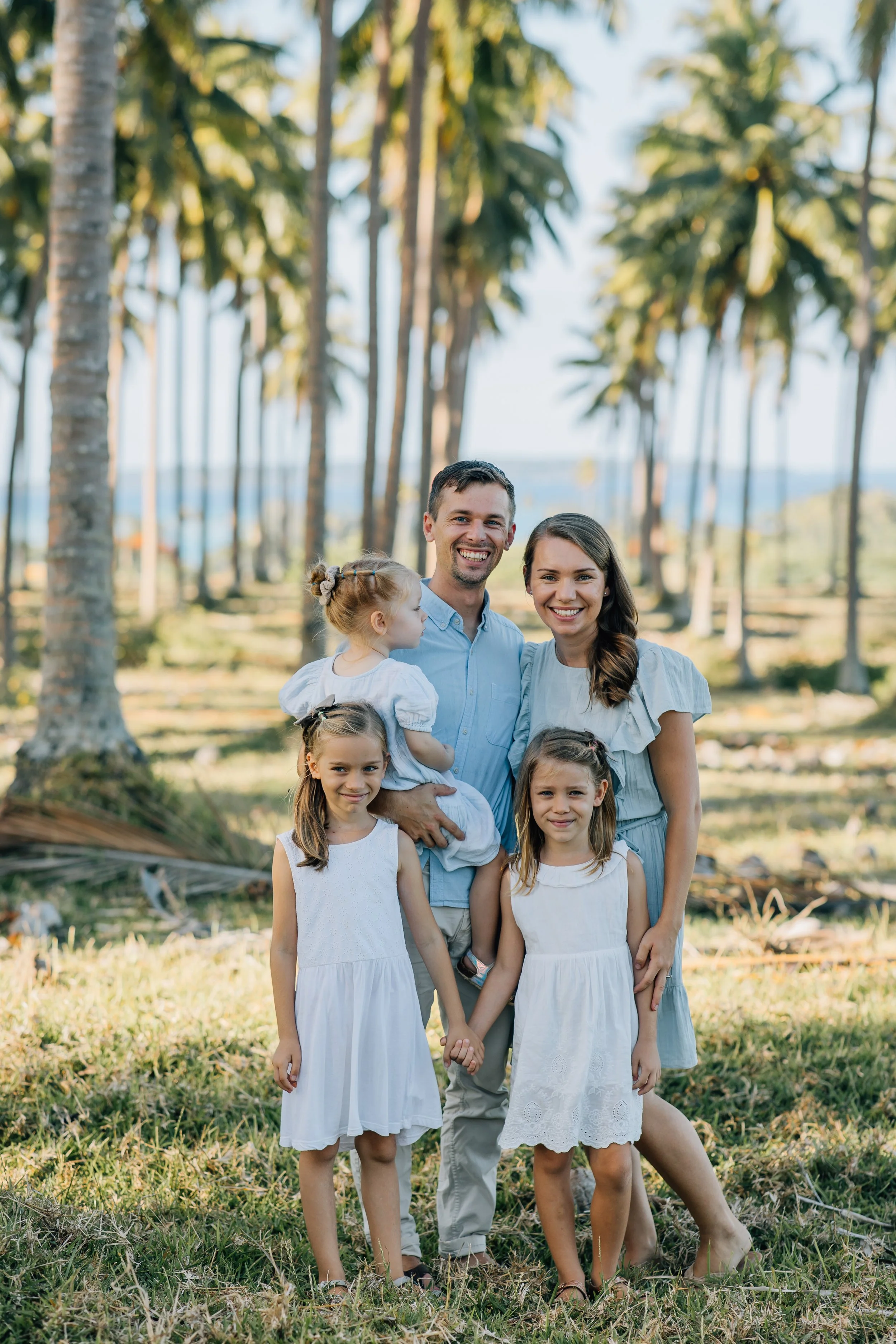 family under palm trees plantation