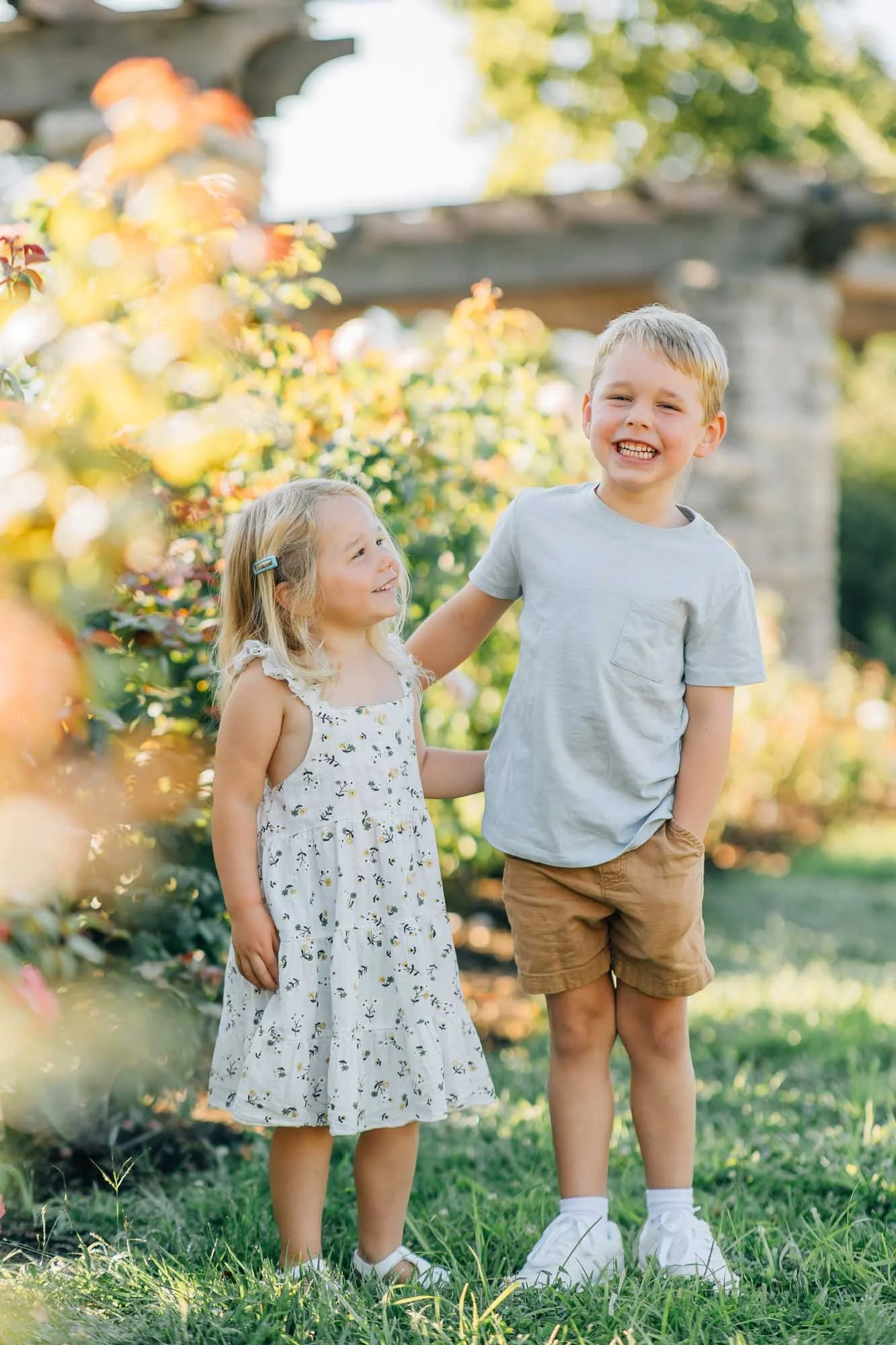 brother and sister posing for photos in a garden