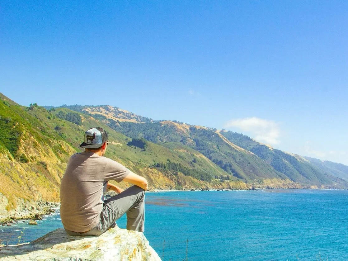 Sitting on a rock overlooking Pacific Ocean in Malibu