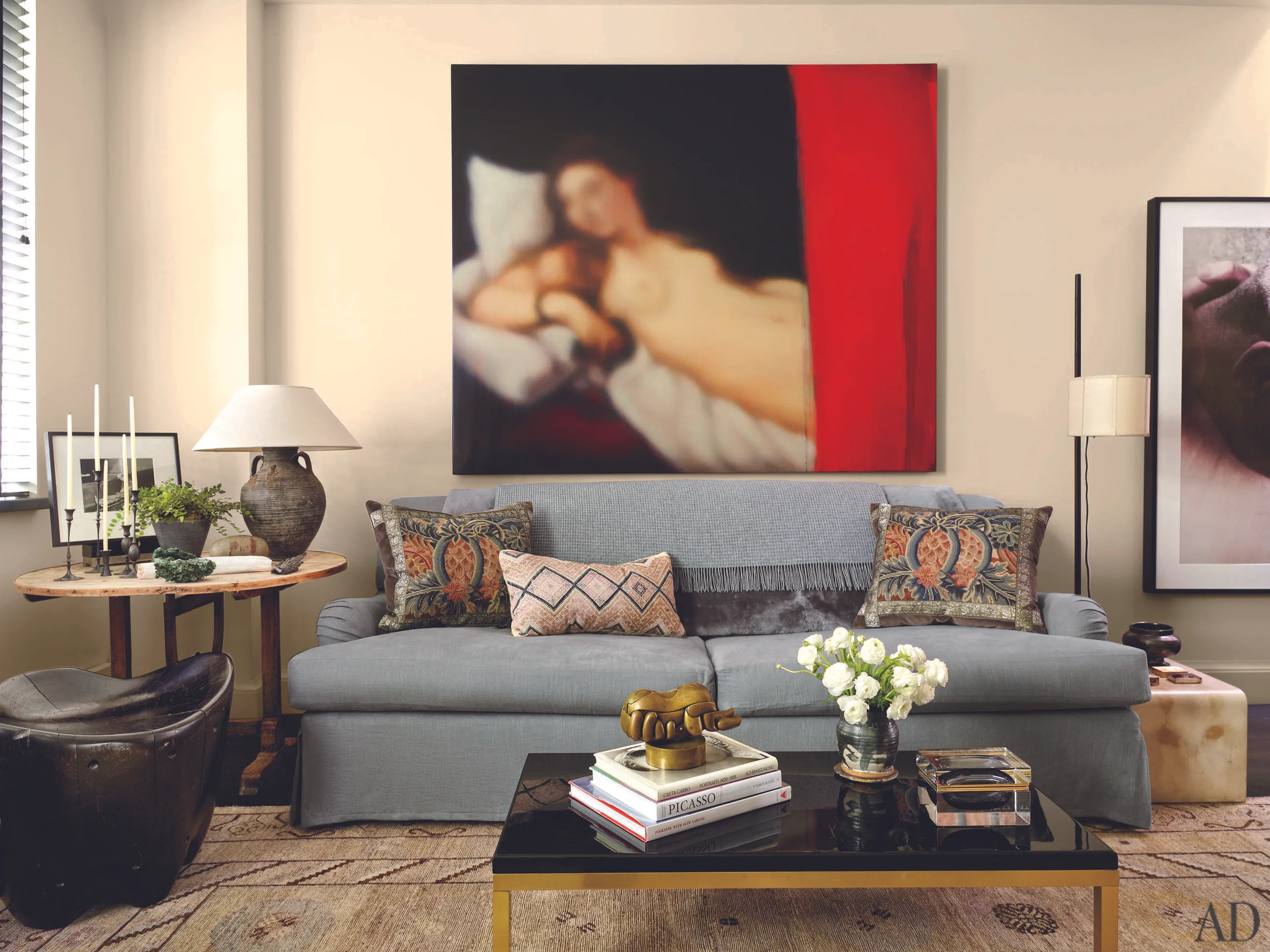 A Jeff Muhs painting hangs above a Bridgewater sofa in the living room; the floor lamp is by Roman Thomas .