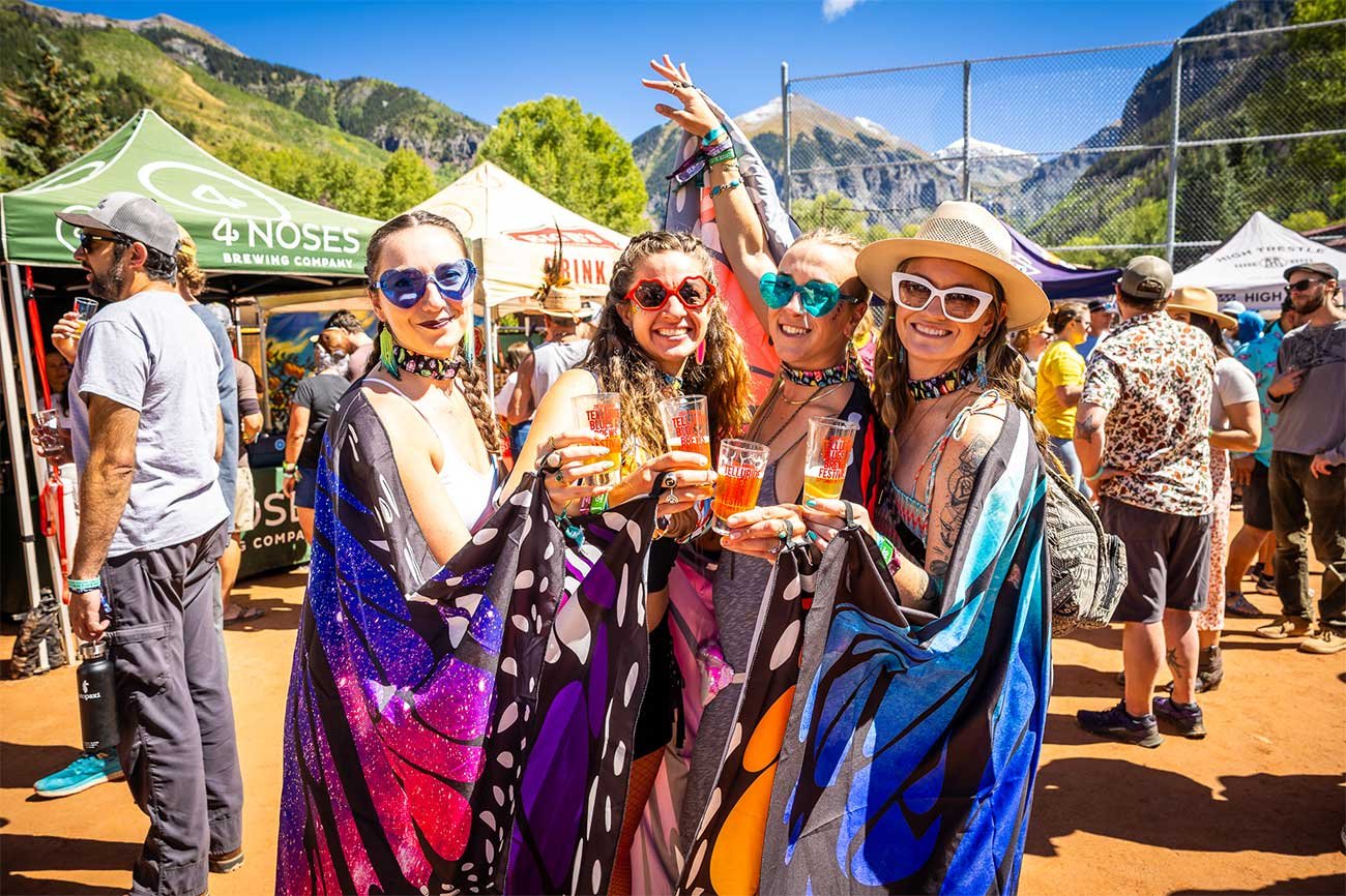 Friends enjoying craft beer together in the beer garden at Telluride Blues & Brews Festival.