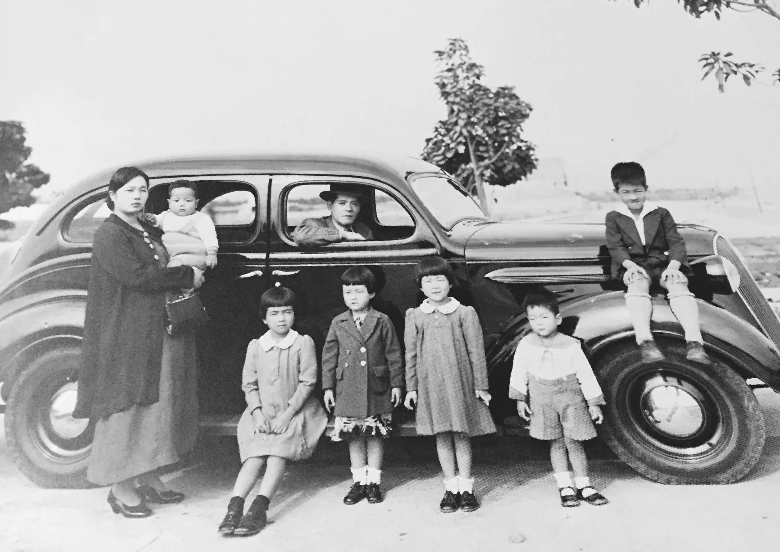 The Shibayama family at a park in Peru. From left to right: Tatsue (mother), Takeshi, Fusako, Akiko, Kikue, Kenichi, Art, and Yuzo (father) in front seat of car.