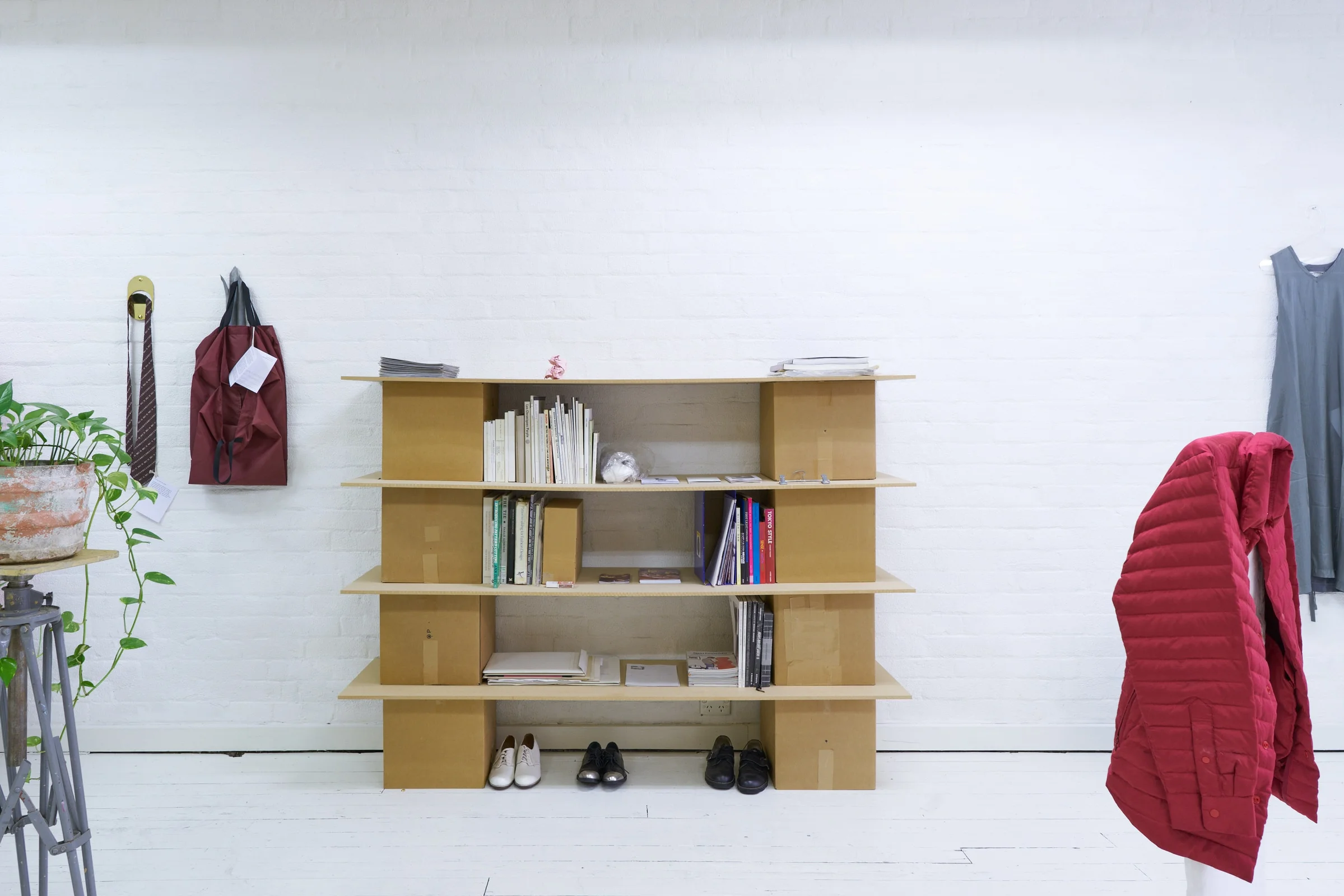 left to right: Timothy Tuppence, To Hang One’s Hat: Home , 2019. Brass, To Hang One’s Hat: Non Home , 2019. Aluminium. Jennifer Mathews, Clothes hanger for insects , 2019. Wire, matchbox, 5.2 x 3.5 x 1.3cm. (small scale on bookshelf). Nathan Peacock, Model for eLLe magazine , 2017. Plaster, wood, metal wire. (shouldering red puffer jacket) Iko Iko, Clear Hanger, 2019. Clear plexi. (shouldering Comme des Garçons dress)