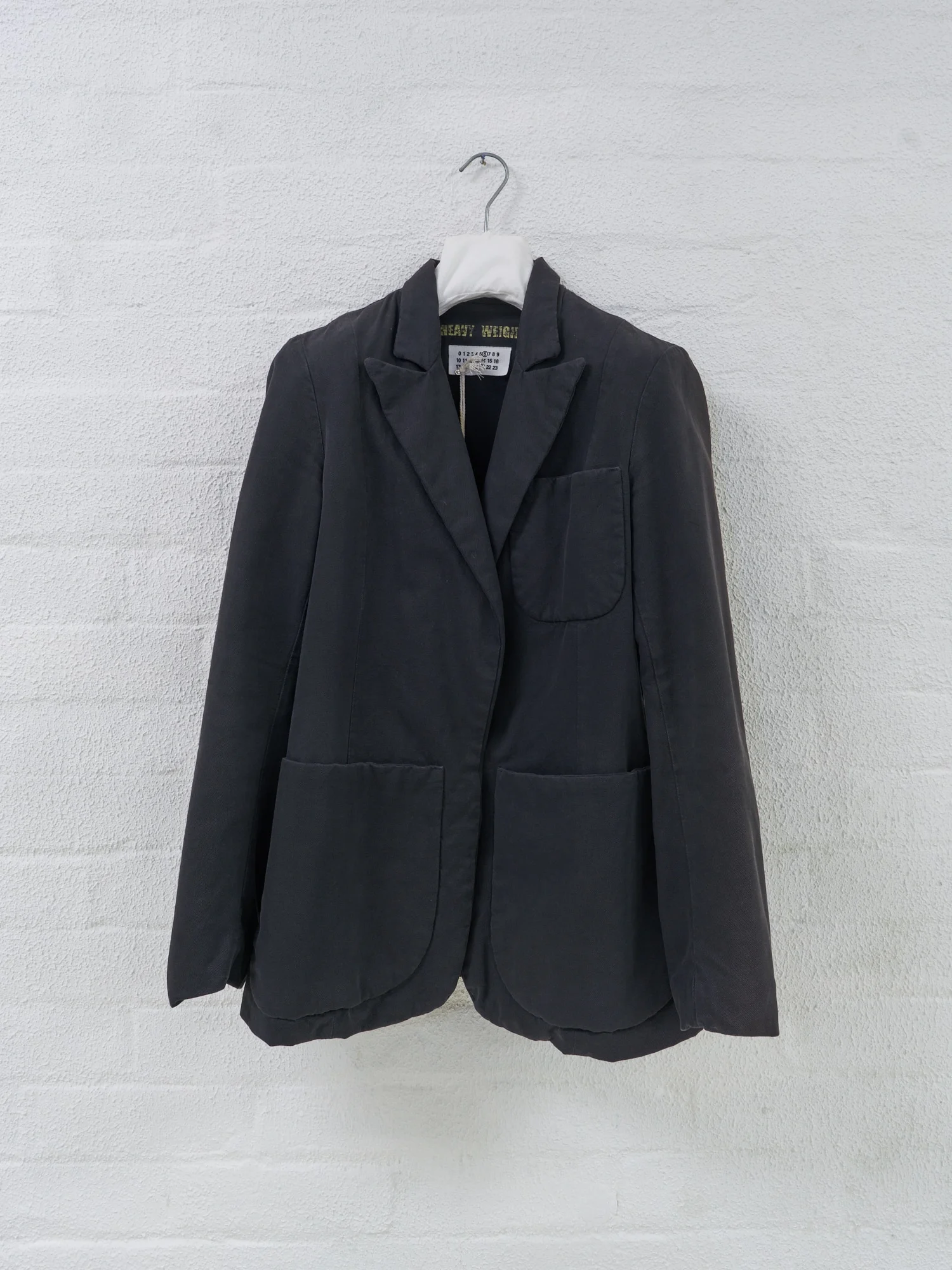 Filter Store, Maison Martin Margiela fabric covered jacket hanger, Mid-2000s. Metal, plastic, cotton. Hung with a Margie jacket. This hanger was also nestled amongst others in the racks.