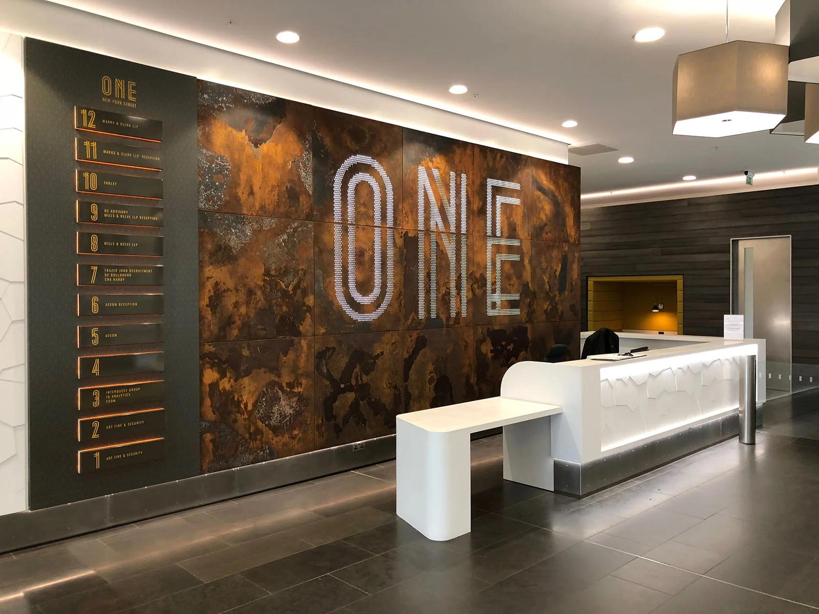 Feature branded light box sign and metal patina in reception