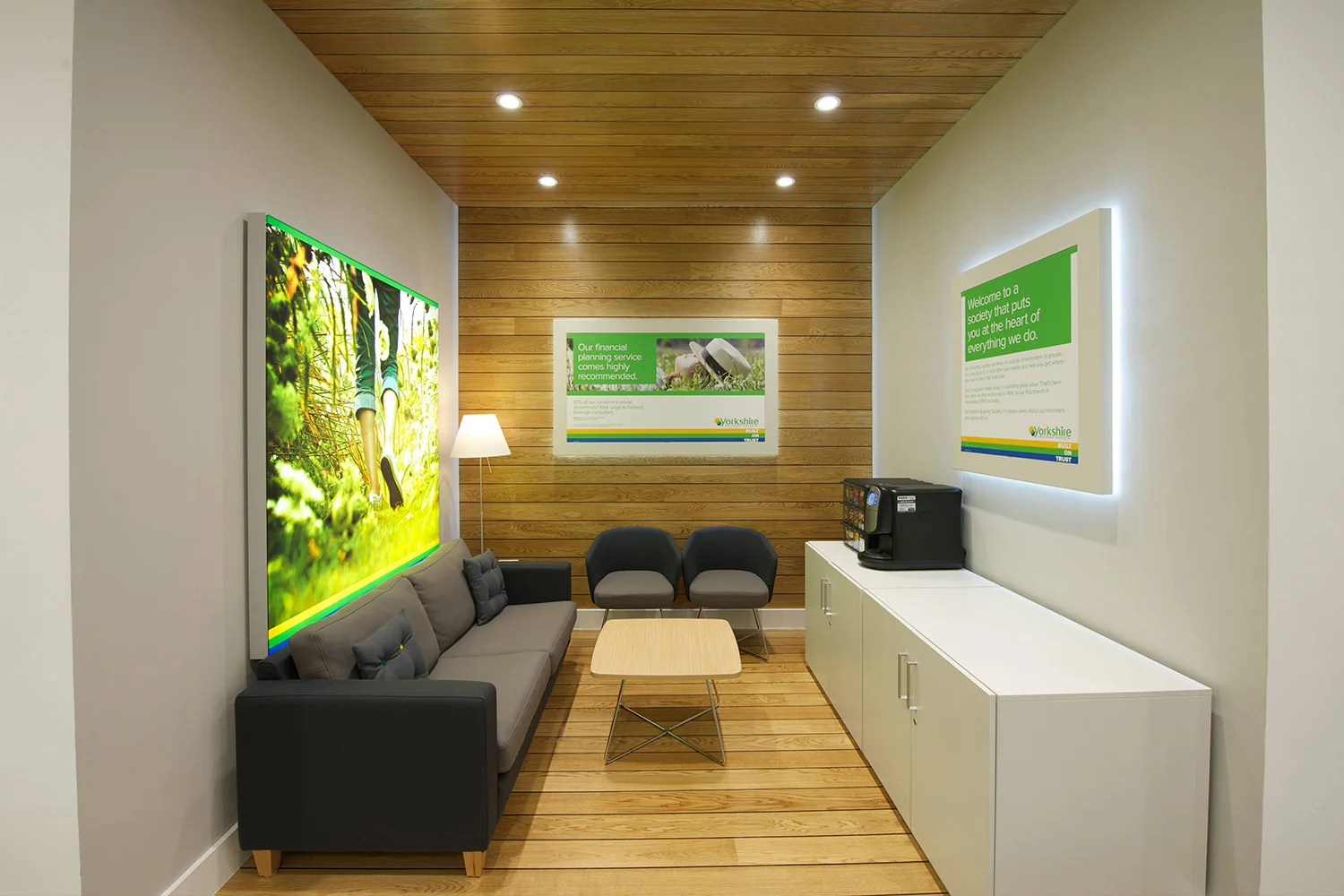 Light box sign with grey sofas and wood flooring