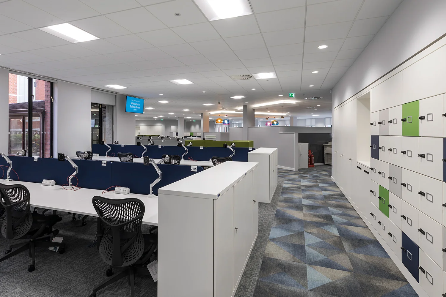 Office desks with blue and green lockers