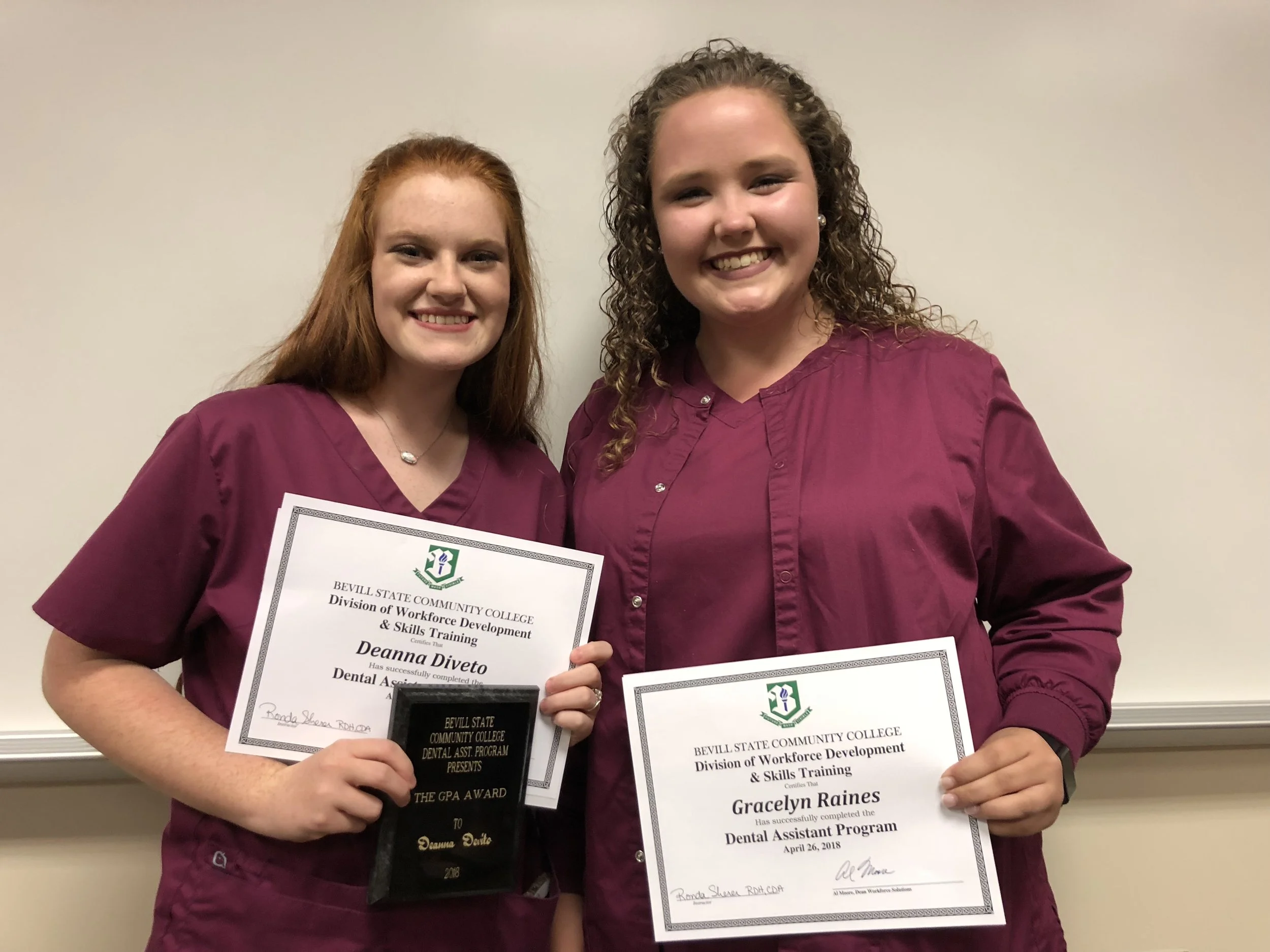 Morgan and Gracie display their diplomas at the Dental Assistant Program graduation ceremony.