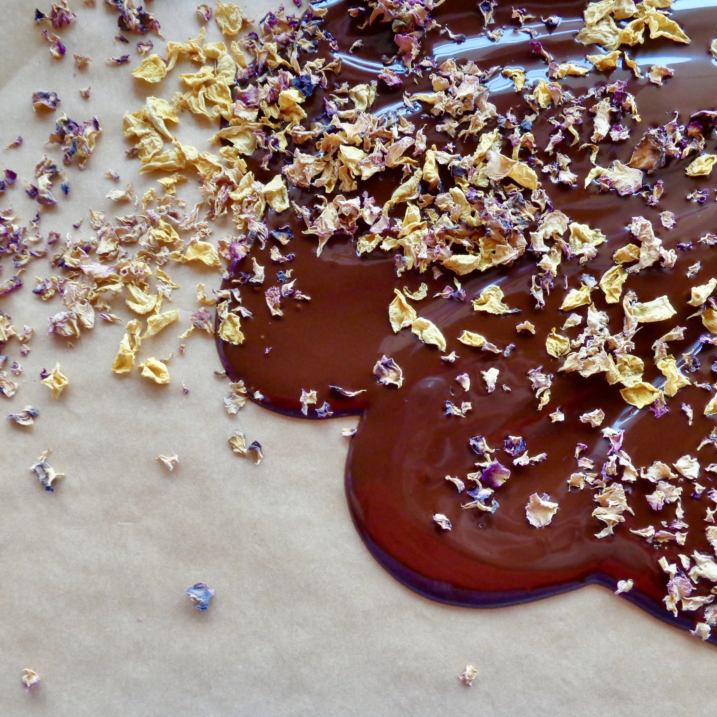 Rose petals from Harvest Home Flowers strewn on some fresh dark chocolate.