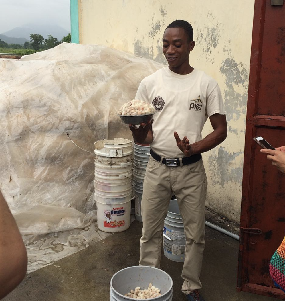  PISA worker Chiquito holds a bowl filled with wet cocoa beans and pulp that were recently harvested. He is showing how they measure the cocoa they buy from the farmers. 