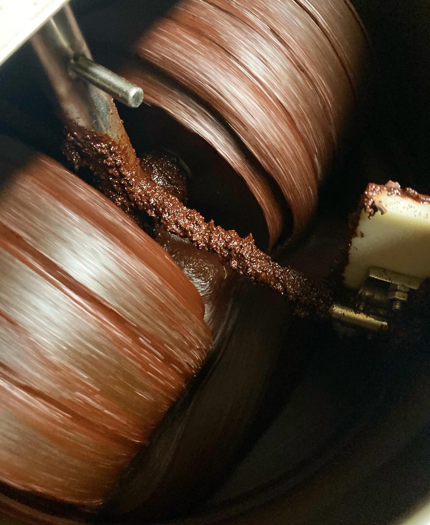  The stone rollers inside the melanger grinding cacao. 