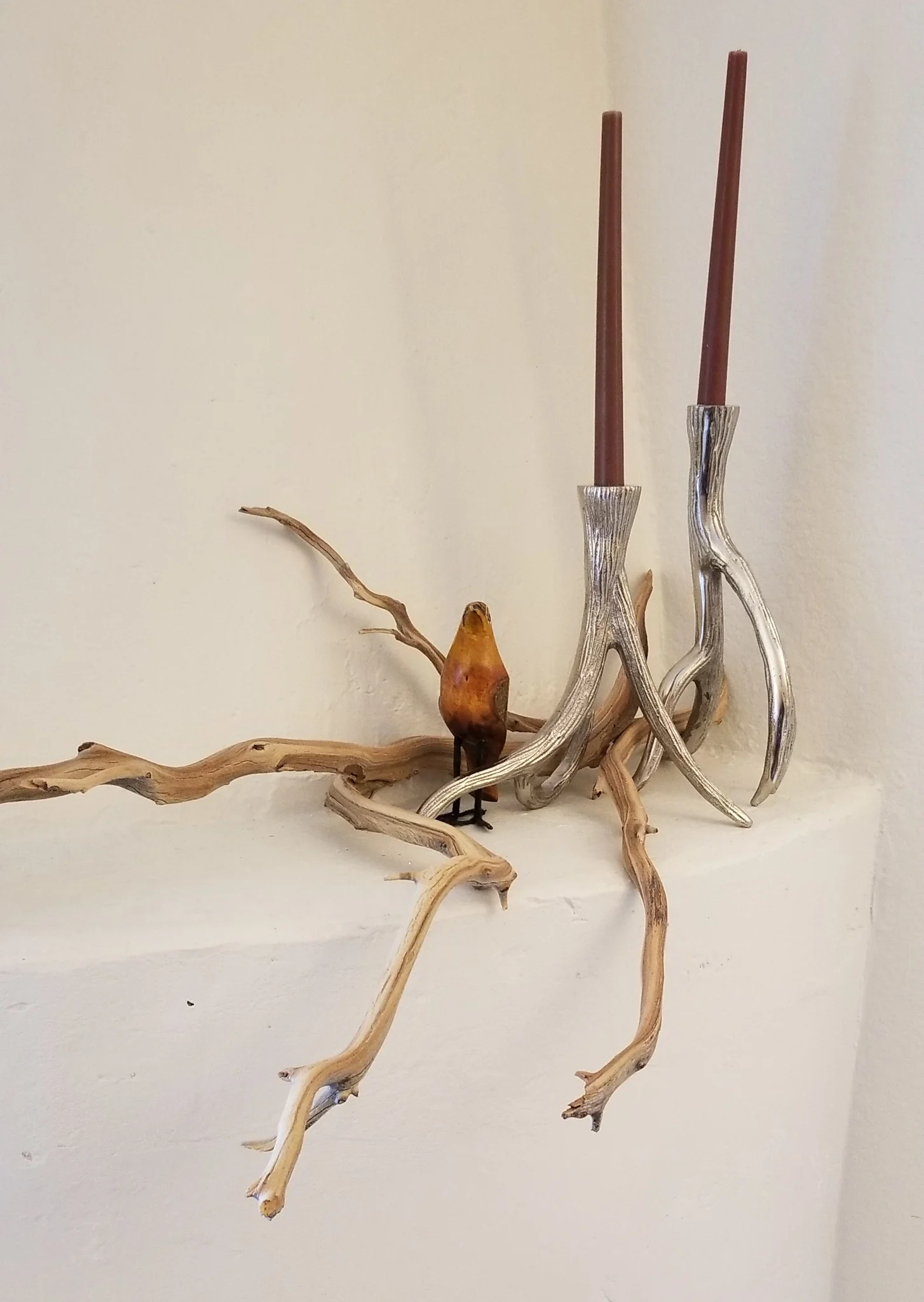 Branches, metal candlesticks, and a wooden bird make a delightful statement!