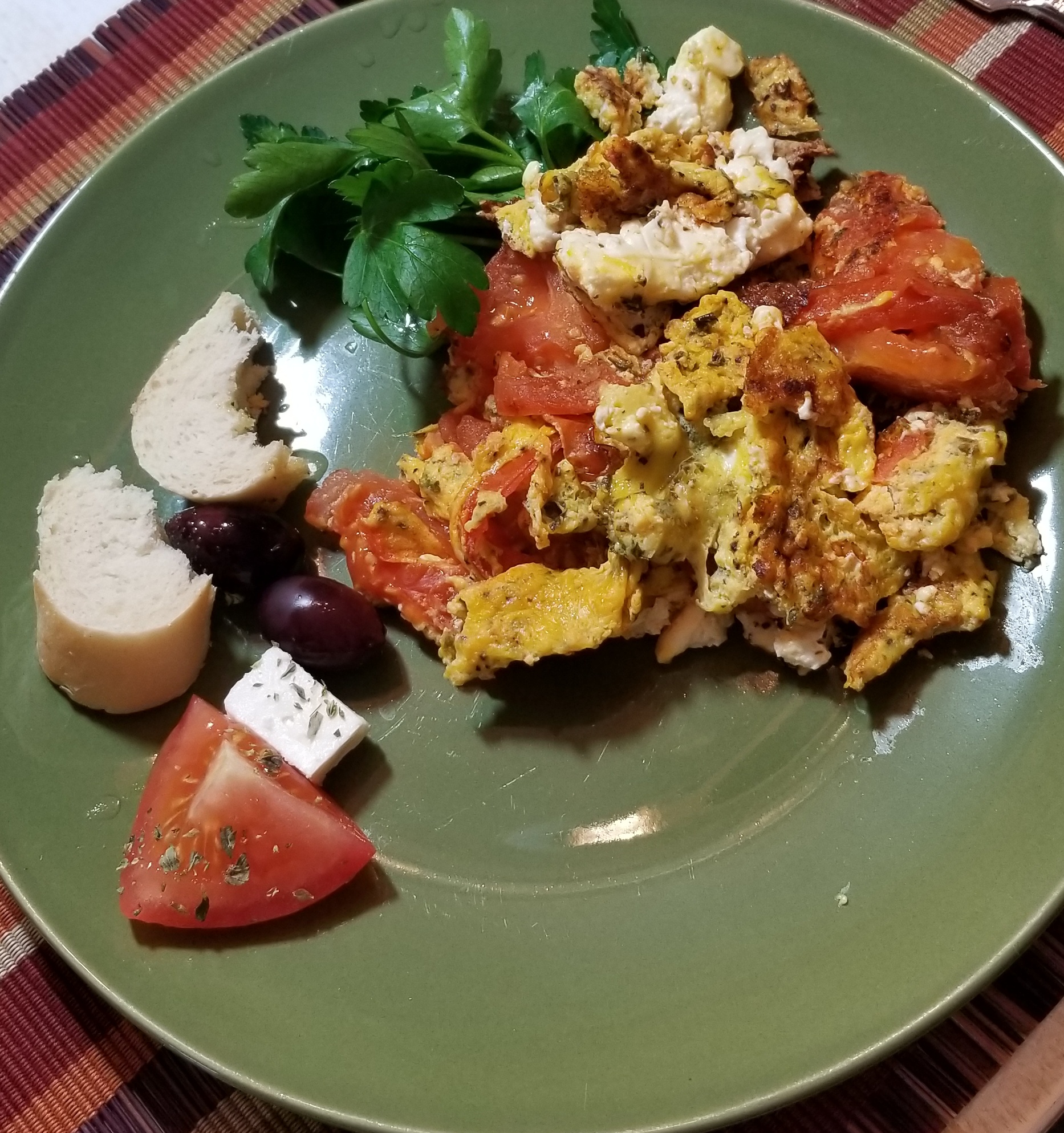 Plated with a bit of bread, olives, more tomatoes and cheese!
