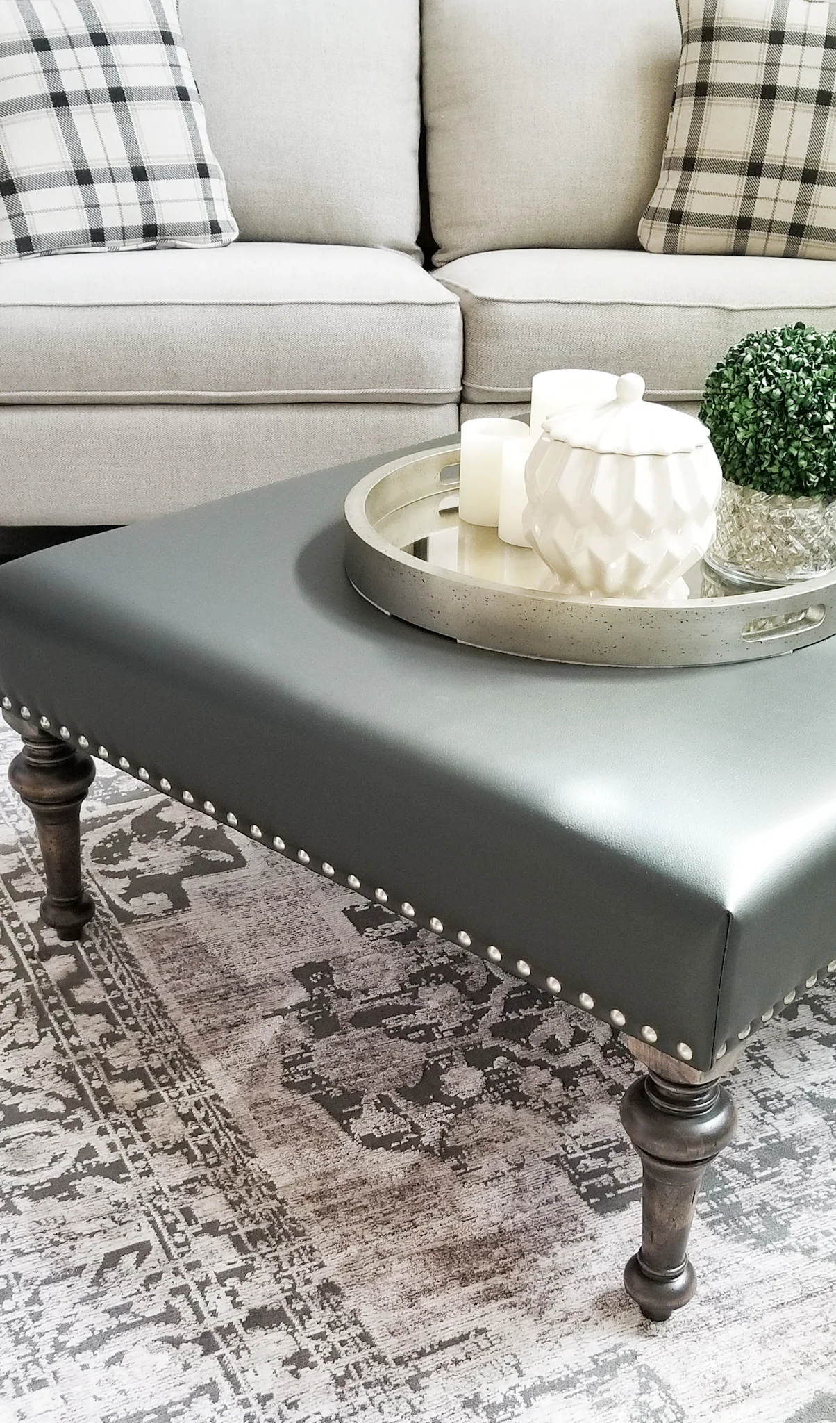 Turned leg ottoman in gray leather.