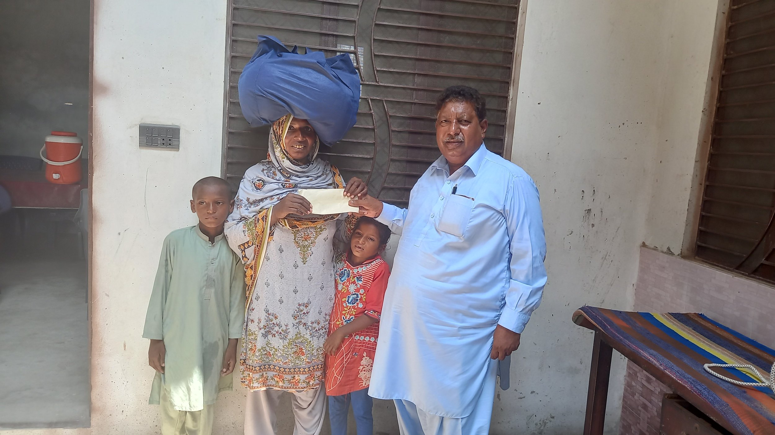  Irshad Bibi receives food bag &amp; support 