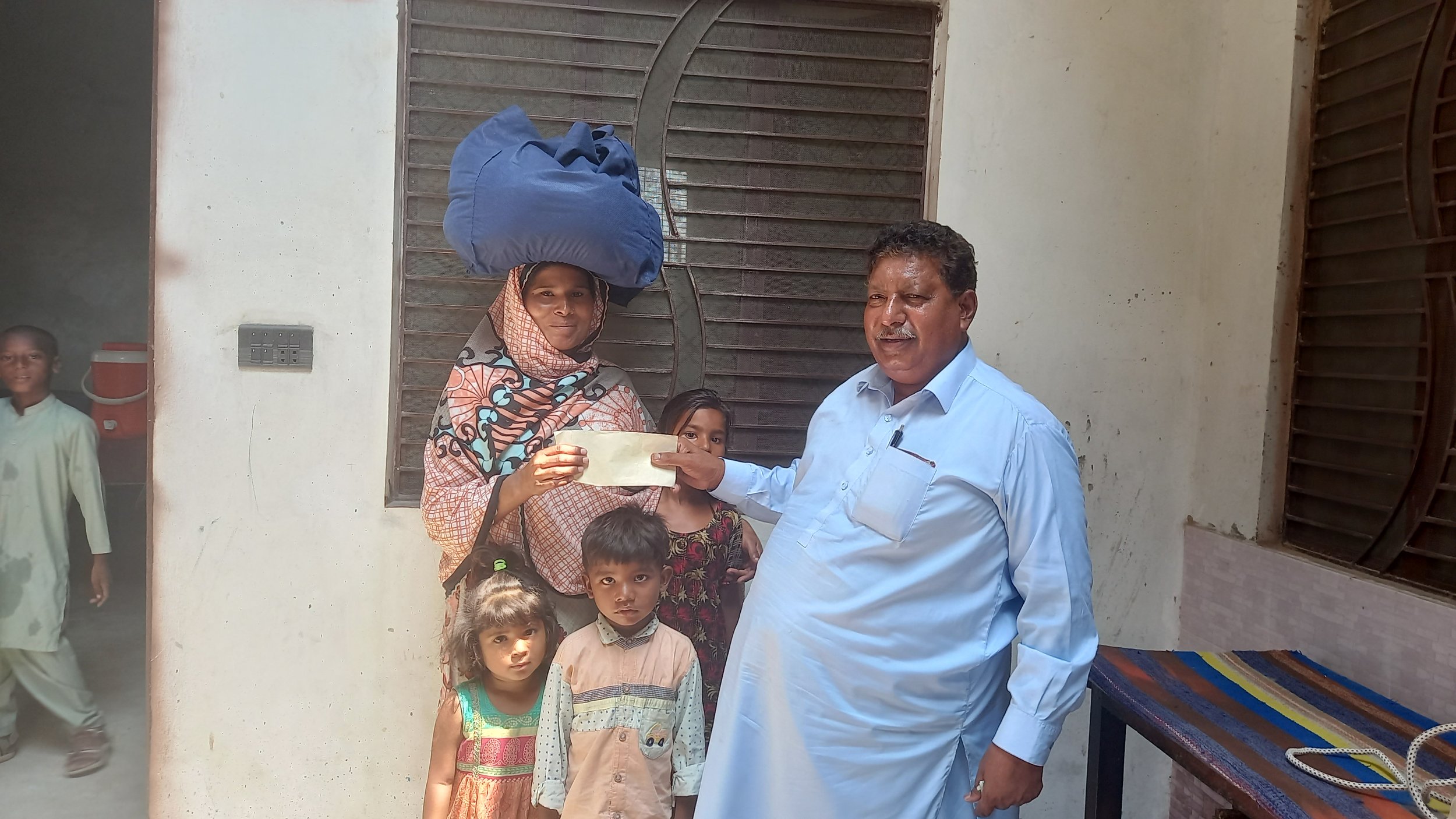 Nadia receives food bag & cash from Pastor Saleem Raza.jpg