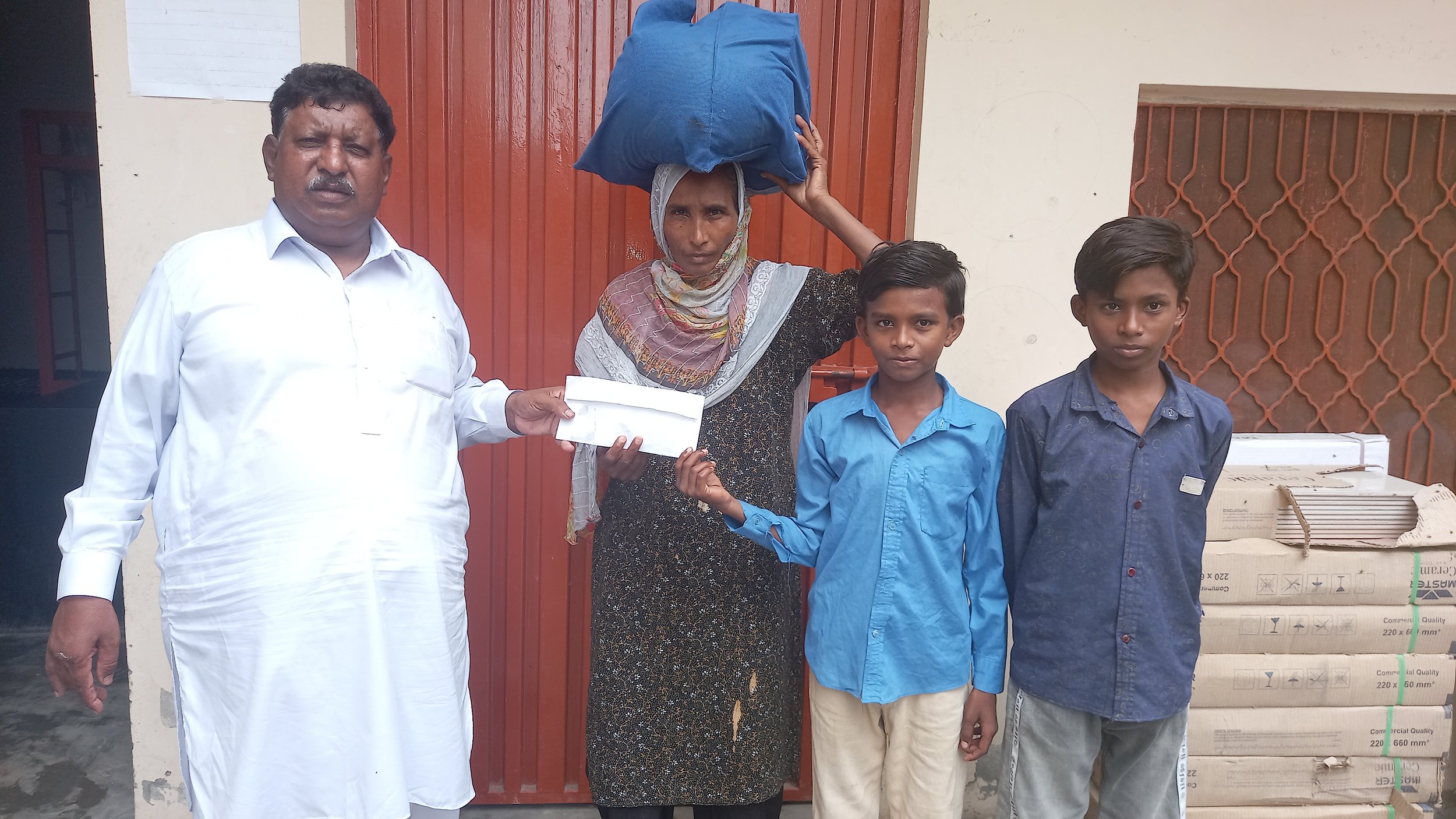 Nusrat Bibi receivves cash & food bag from Pastor Saleem Raza.jpg
