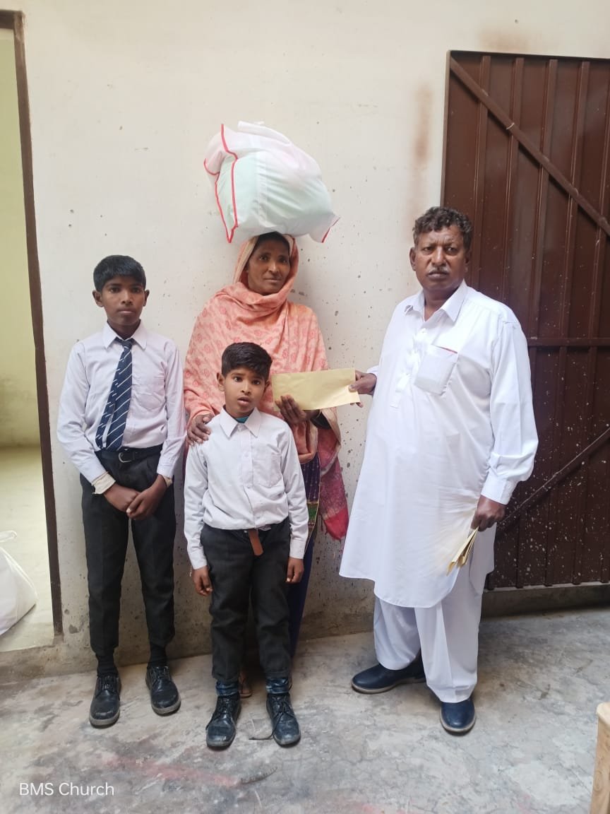  Widow Nasreen receives food bag &amp; aid. 