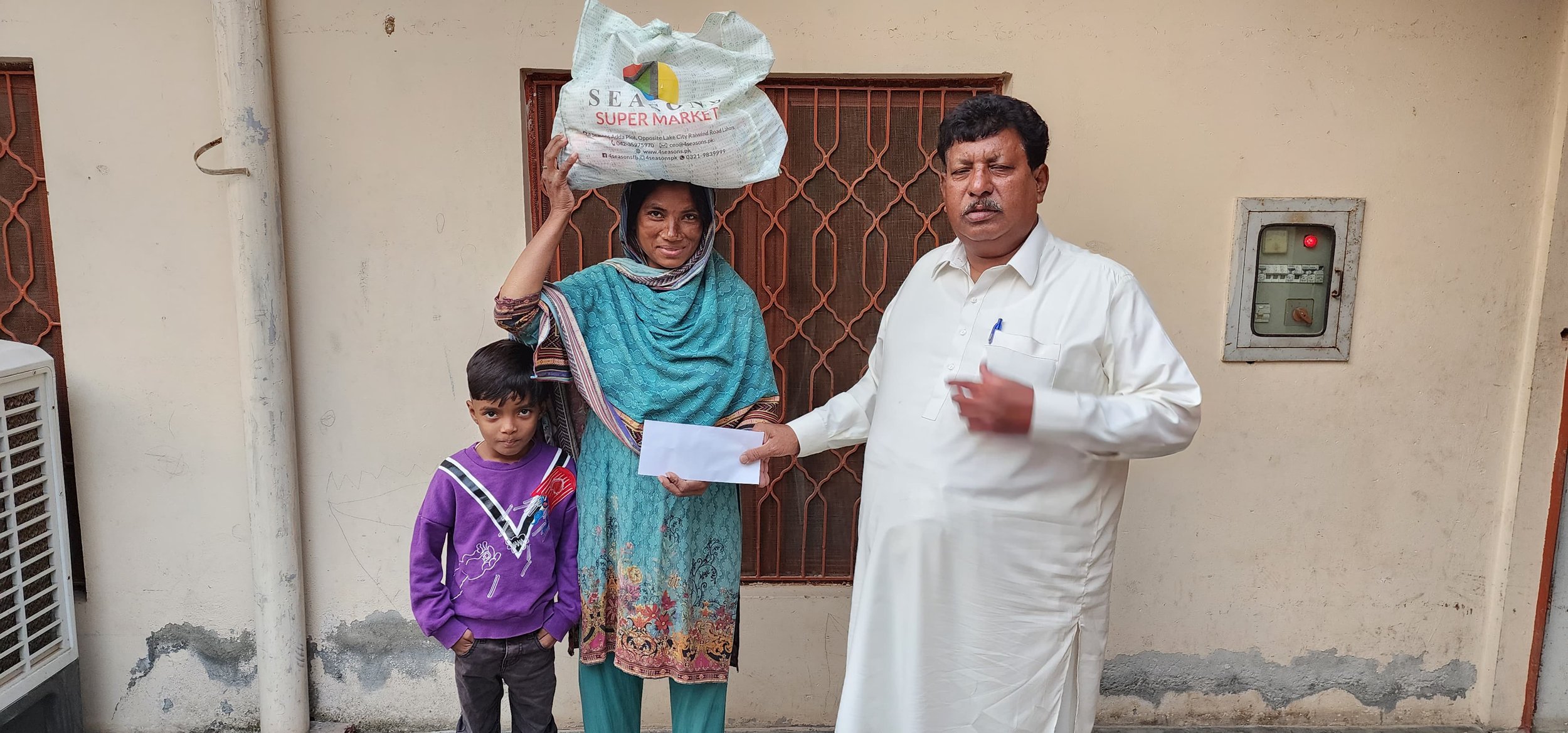 Widow Shakeela receives food bag &amp; other support.