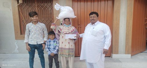 Widow Shakeela receives food bag &amp; support.