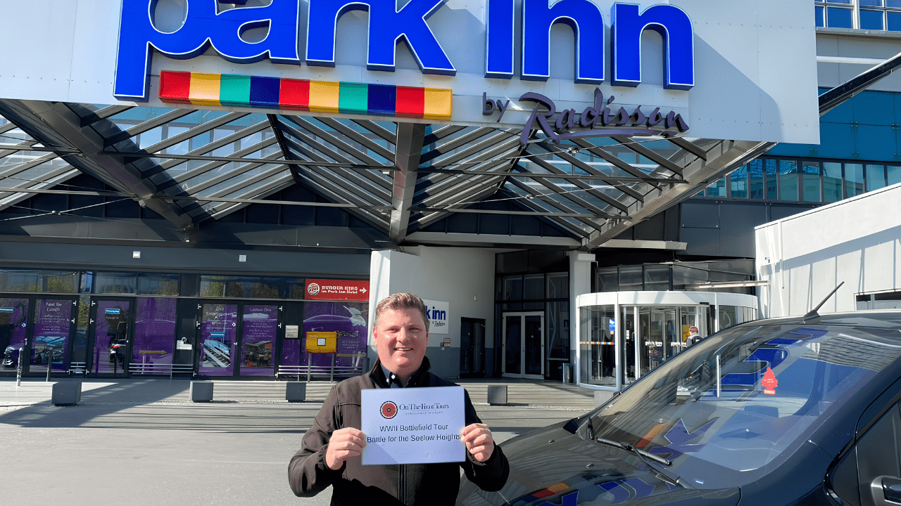 Guide holding an On the Front Tours sign outside the Park Inn by Radisson at Alexanderplatz, Berlin