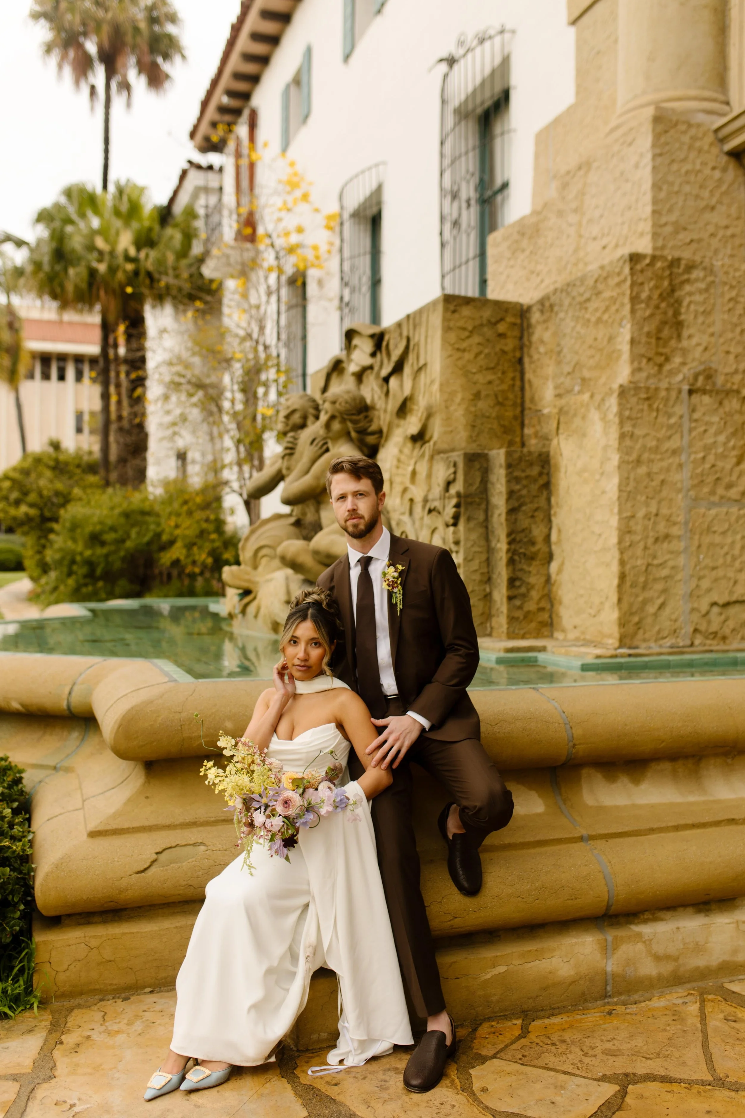 The couple poses at the courthouse fountain—stylish, sweet, and full-on wedding Santa Barbara Courthouse vibes.