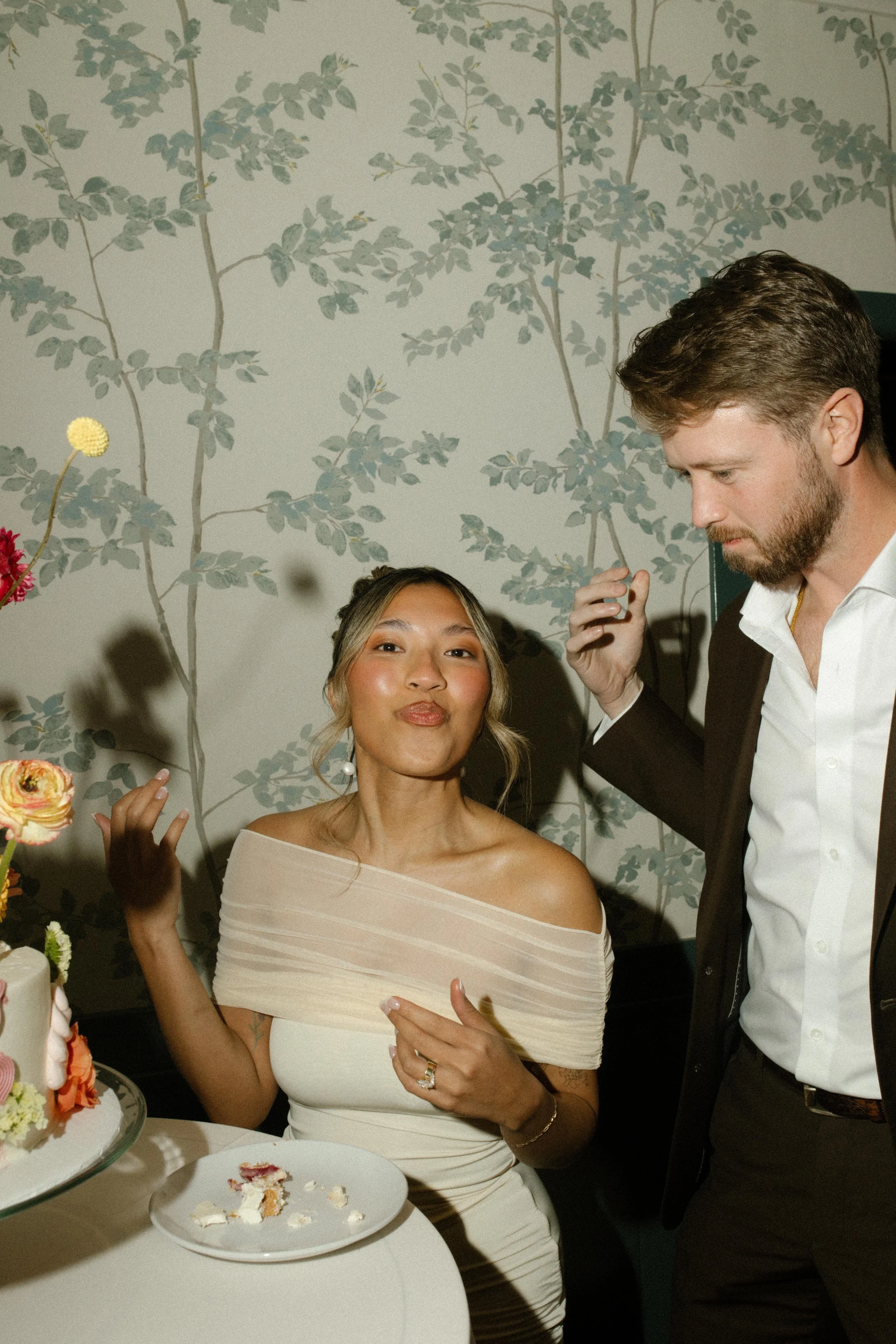 Bride grins with cake on her plate while the groom sneaks a bite—post-wedding Santa Barbara Courthouse bliss.