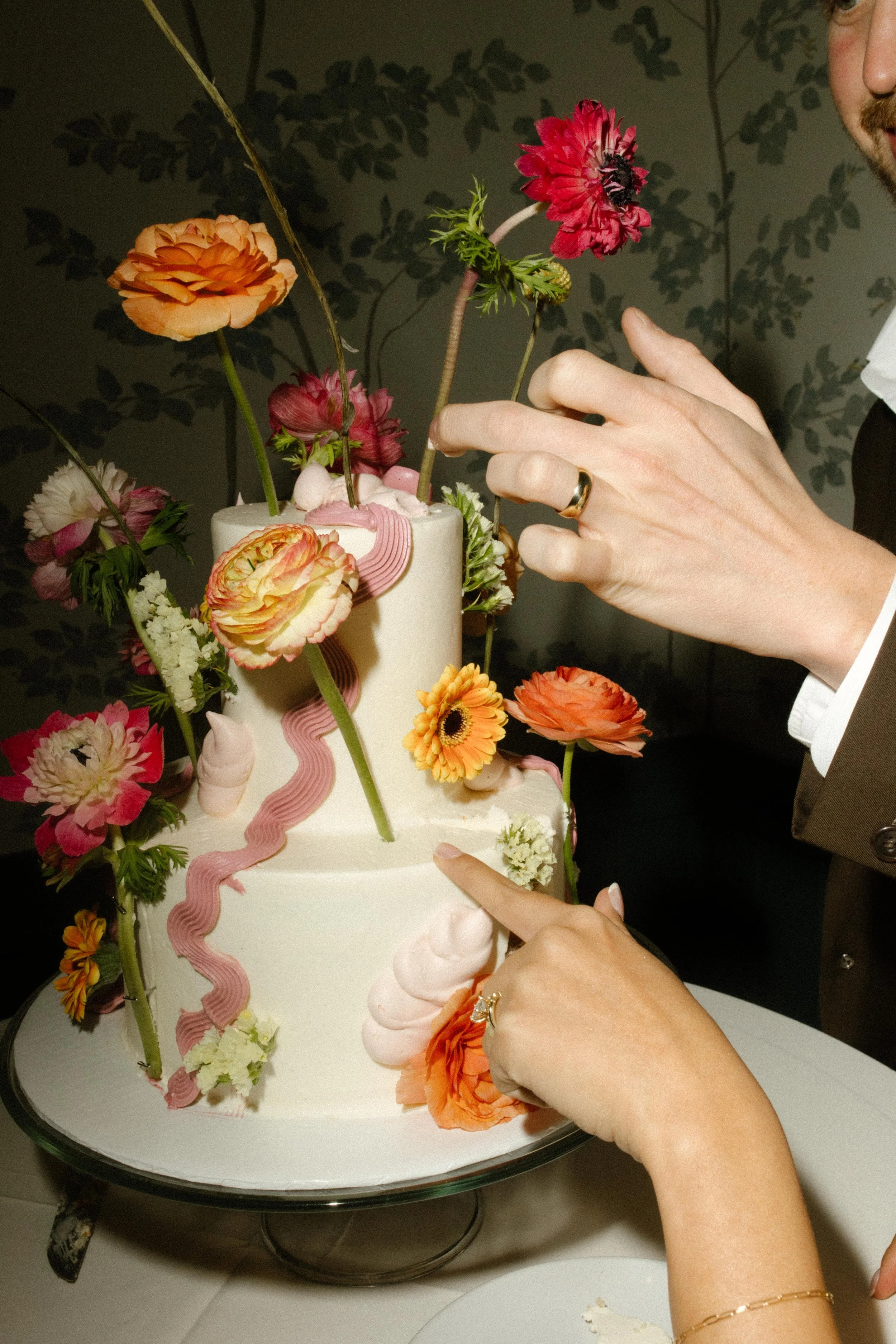 Hands reaching for cake, flowers everywhere—sweet moments post-wedding Santa Barbara Courthouse.