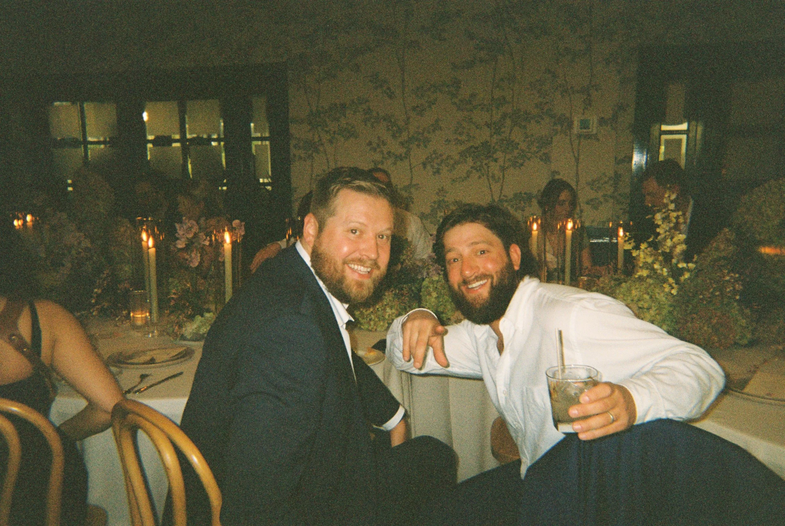 Two guests smiling at the camera during the reception.
