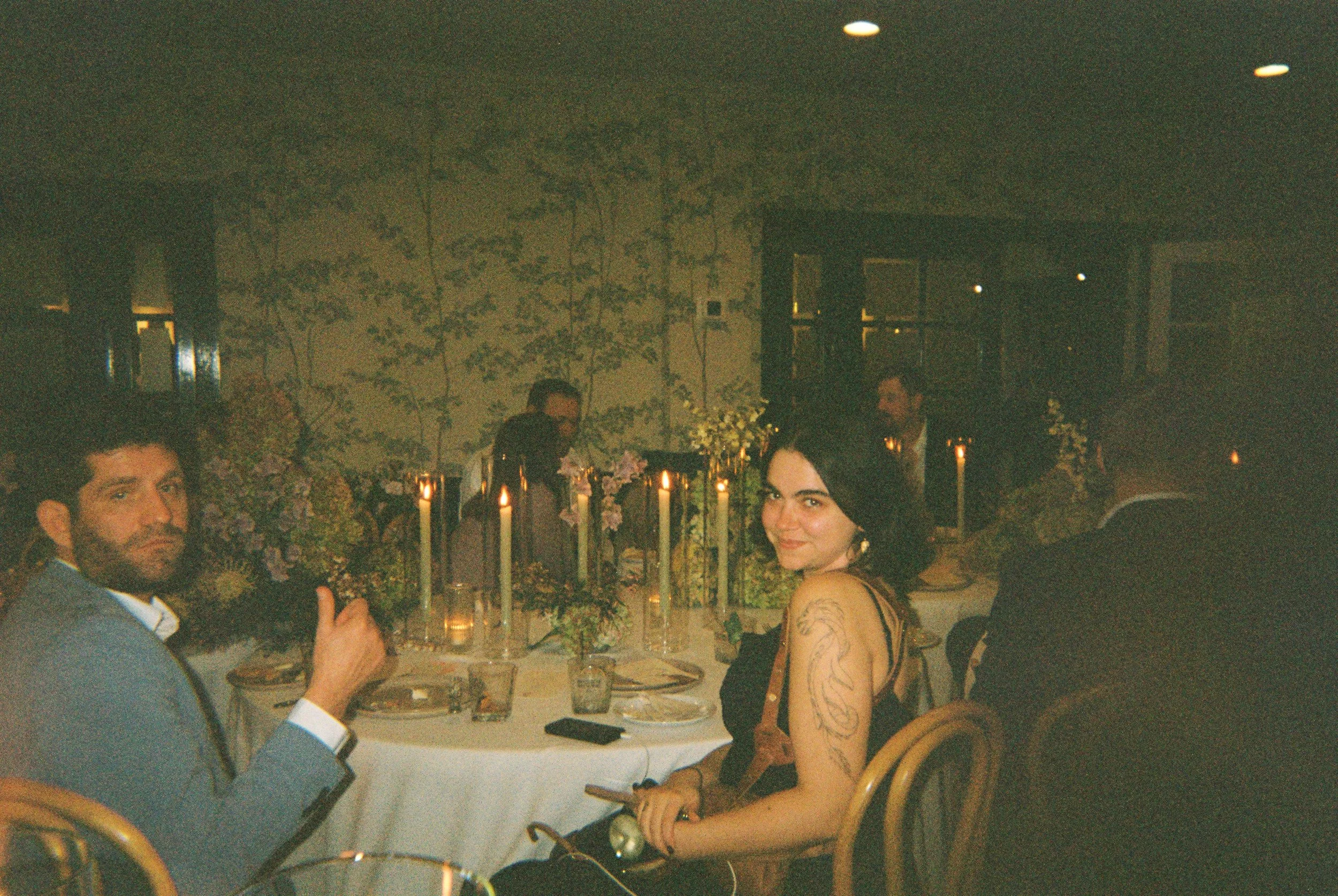 A guest turning to smile mid-conversation at dinner.