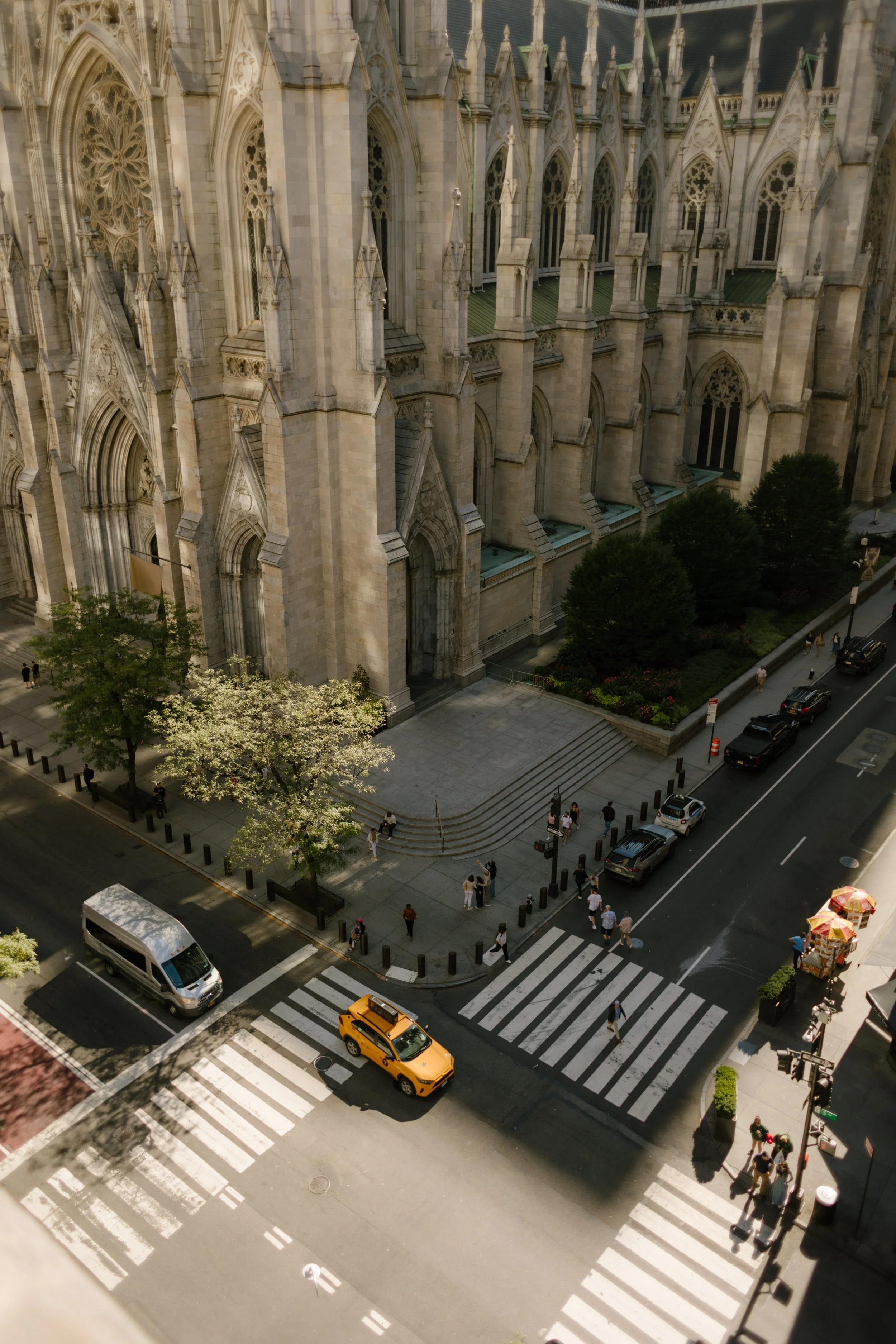 Overhead view of St. Patrick’s Cathedral and a bustling Manhattan street below, complete with yellow cabs and hot dog stands—the heartbeat of a wedding day in New York City.