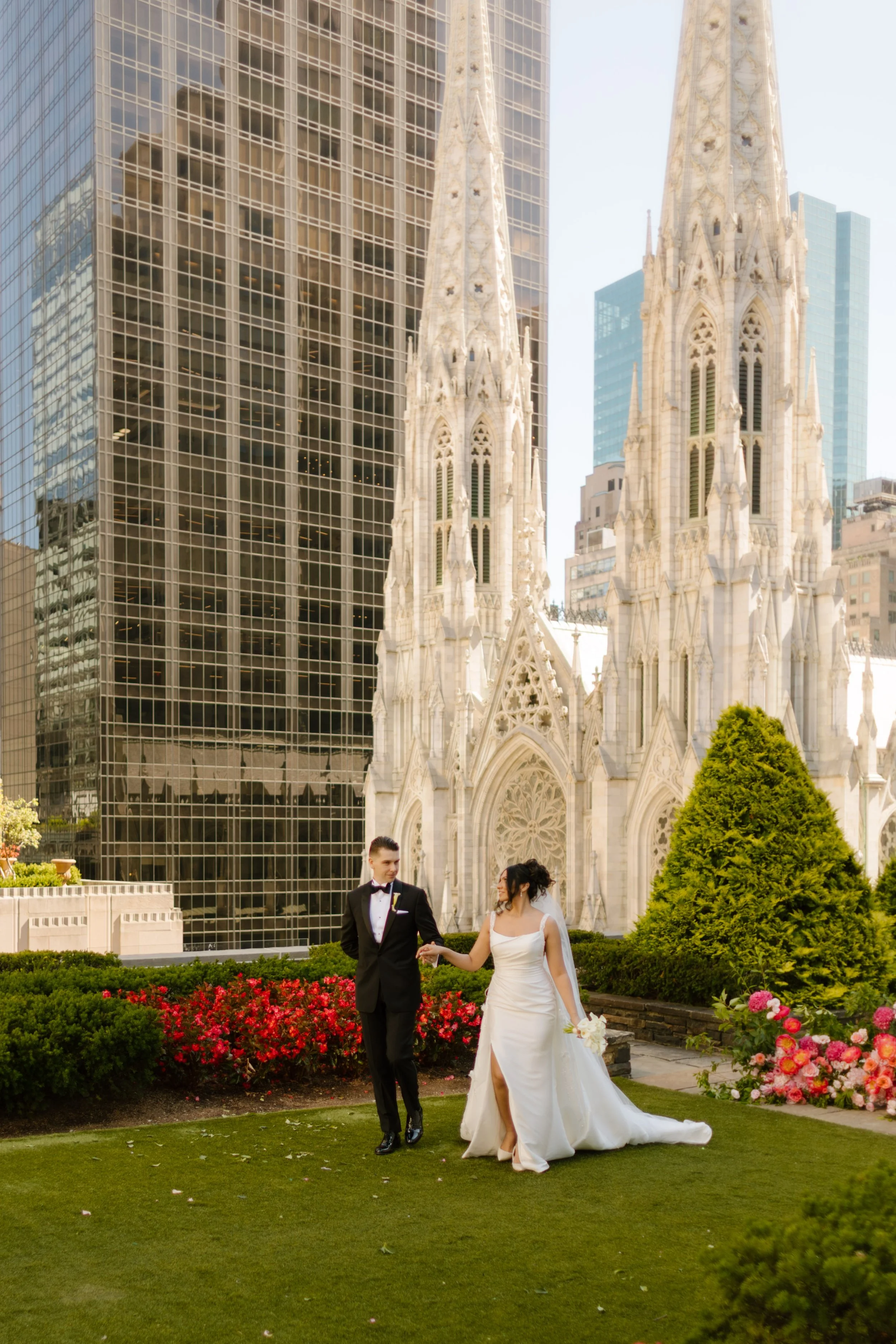 The couple strolls hand-in-hand through the rooftop garden, trailing florals and holding onto the high of just saying I do—St. Patrick’s Cathedral watching over their wedding in New York City.