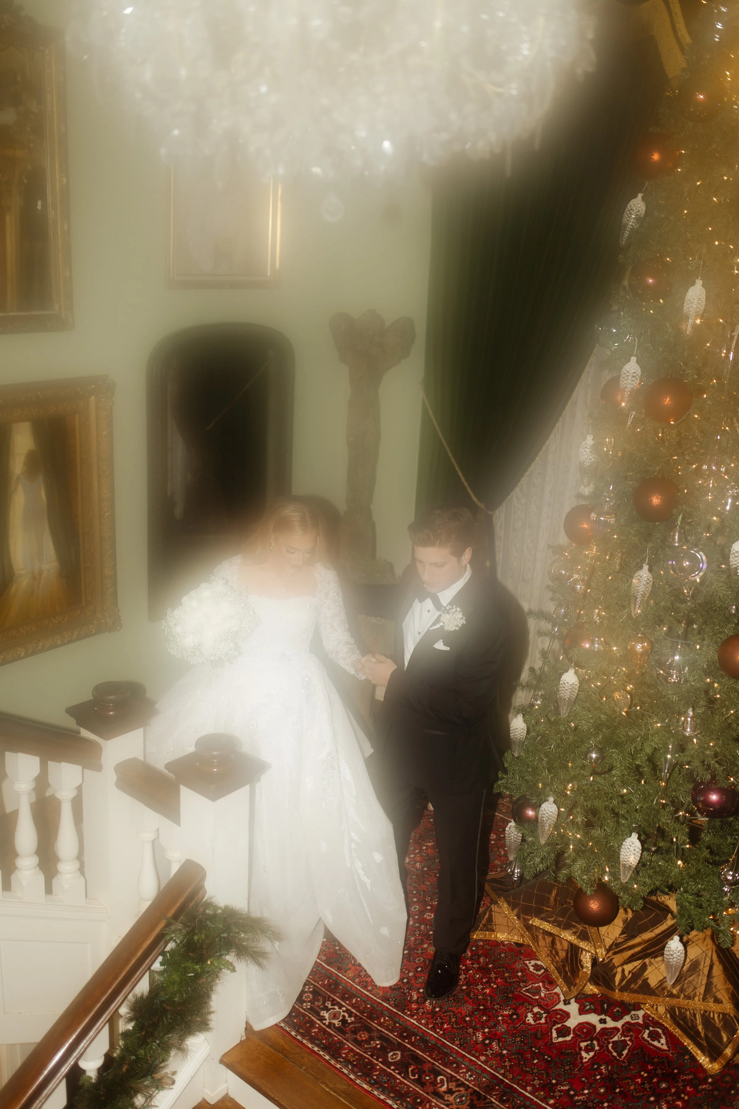 Bride and groom walk triumphantly down the steps of a white-columned estate, surrounded by cheers from their wedding party during their Arkansas wedding.