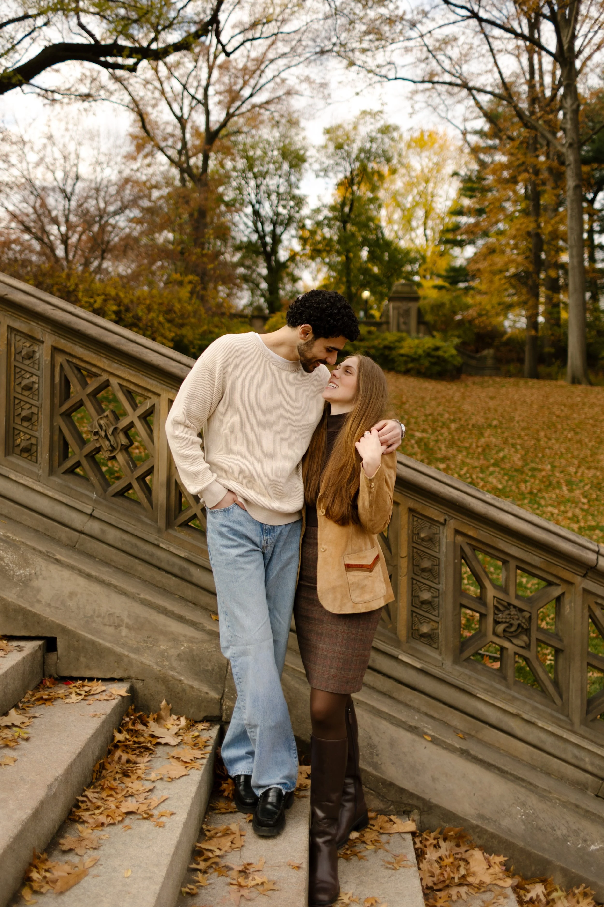 Couple sharing a quiet kiss on the Bethesda Terrace stairs during their Central Park photoshoot in fall.