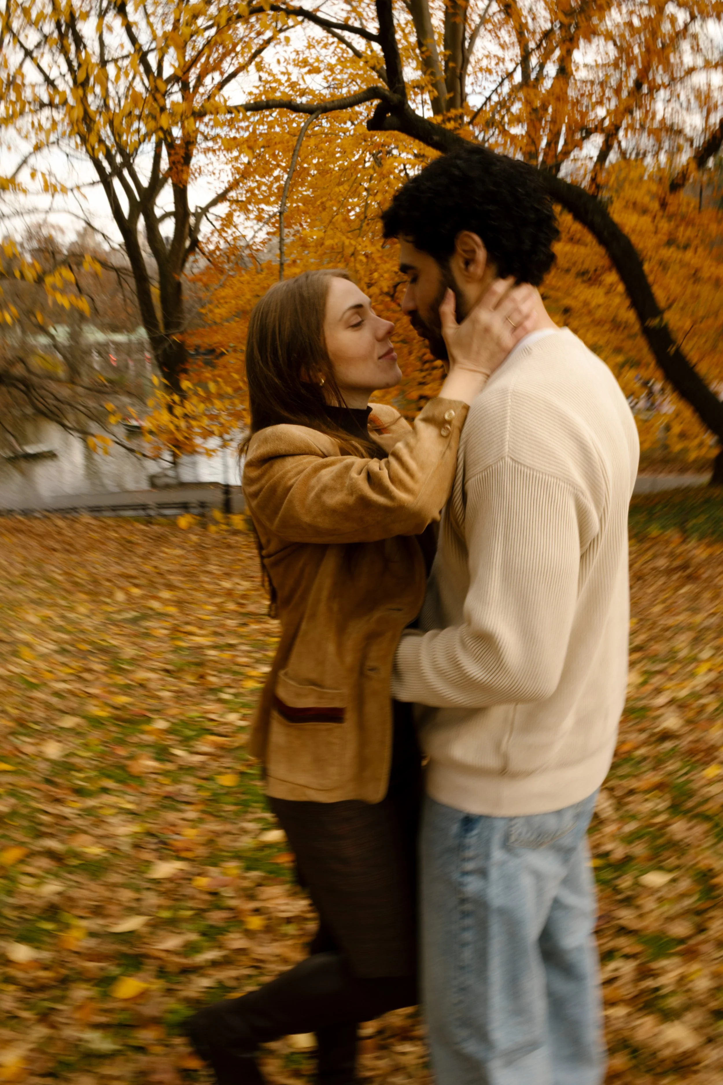 Couple sharing an intimate, slow-dance moment under golden fall trees during their Central Park photoshoot.