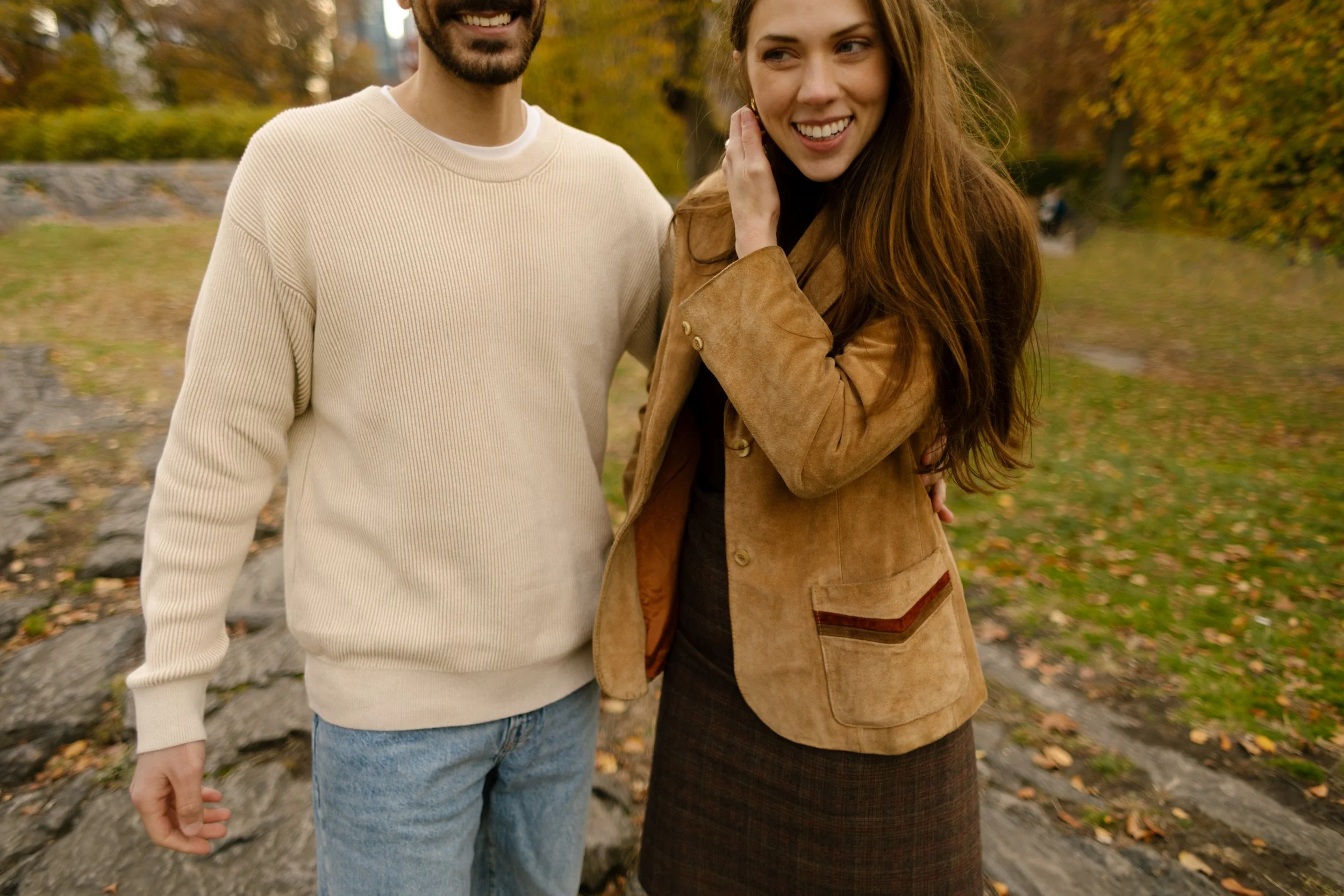 Candid close-up of a couple laughing and standing arm-in-arm during their Central Park photoshoot.