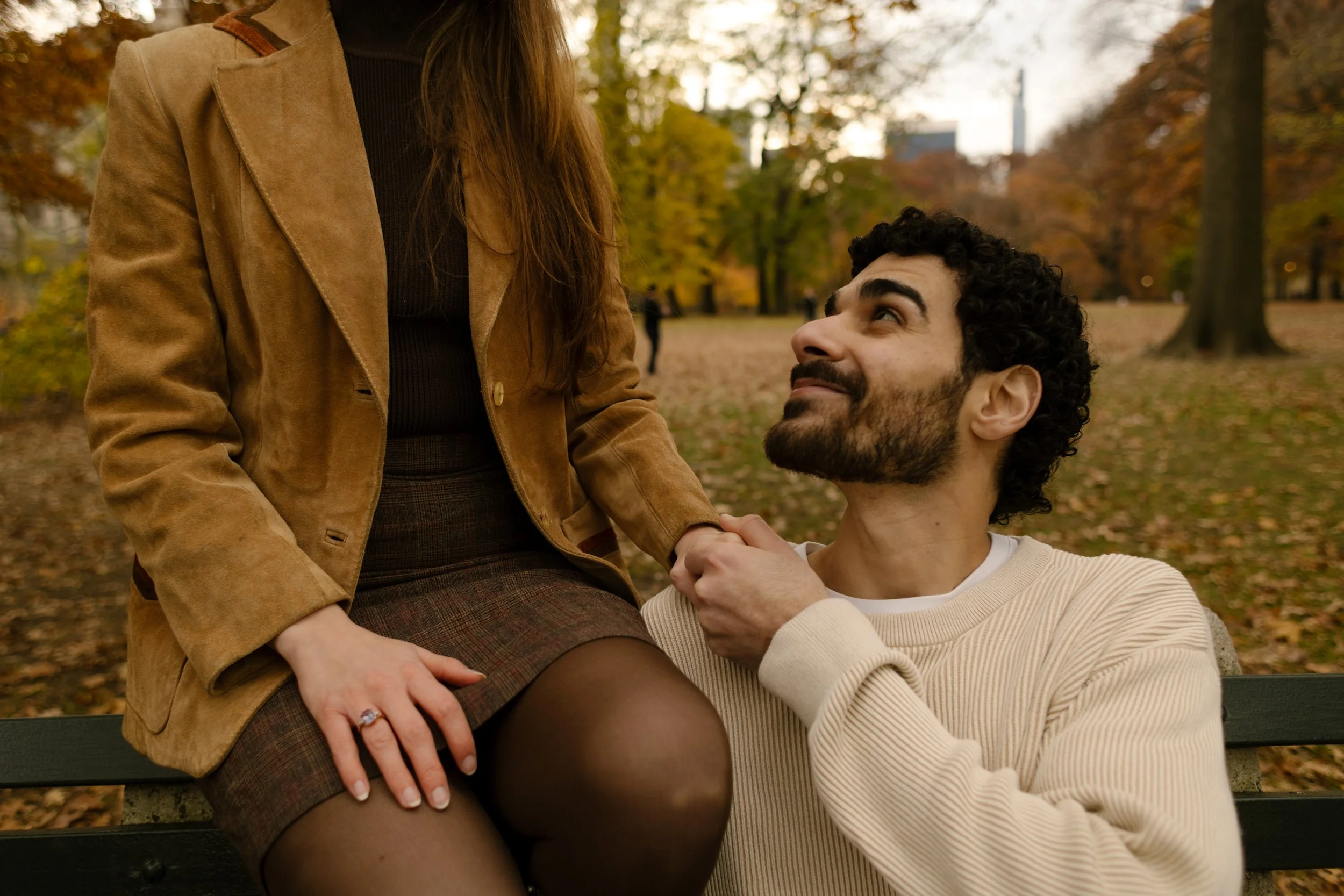 Soft, romantic close-up of a couple making eye contact on a bench during their Central Park photoshoot.