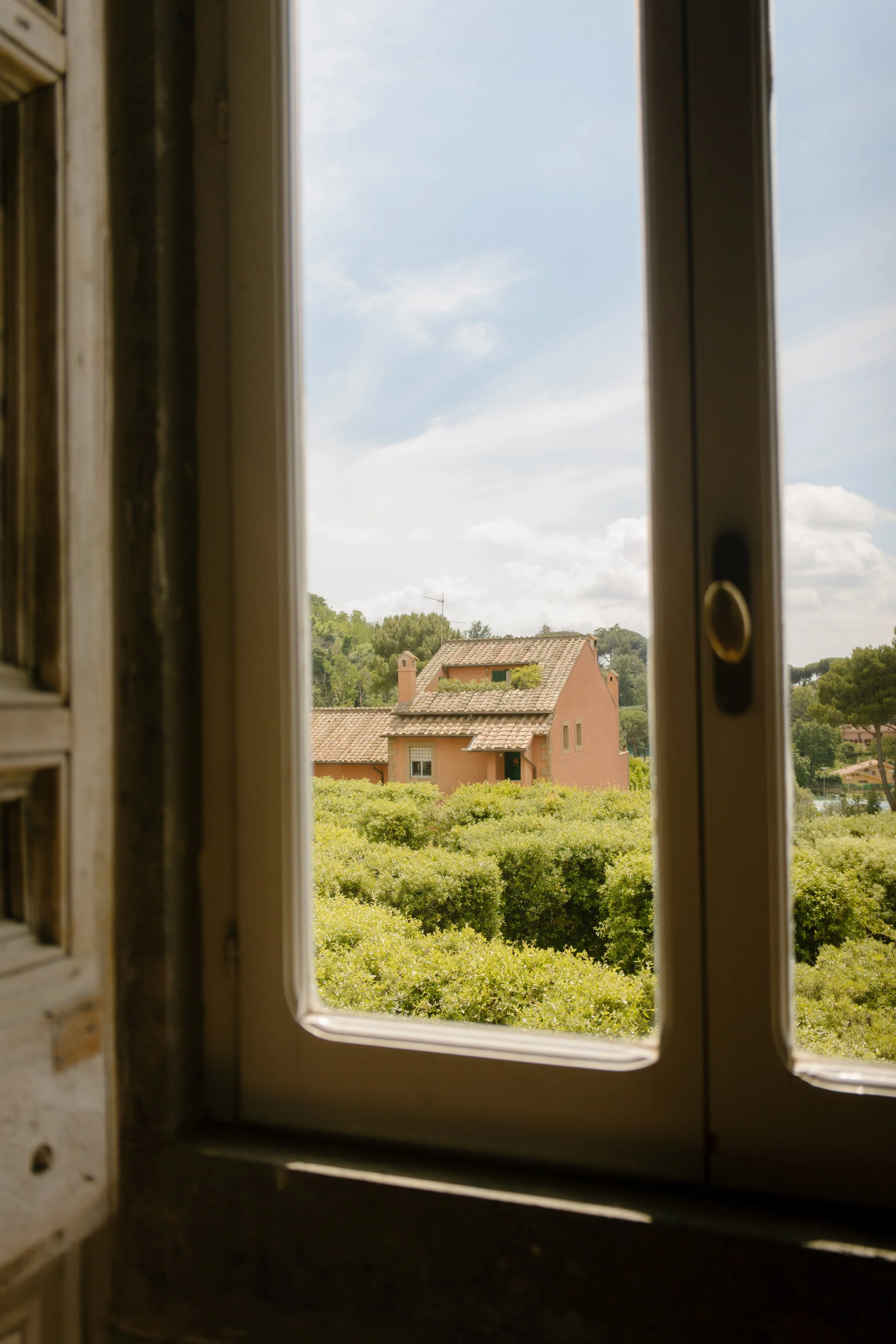 Window view of garden in Italy before wedding rehearsal.