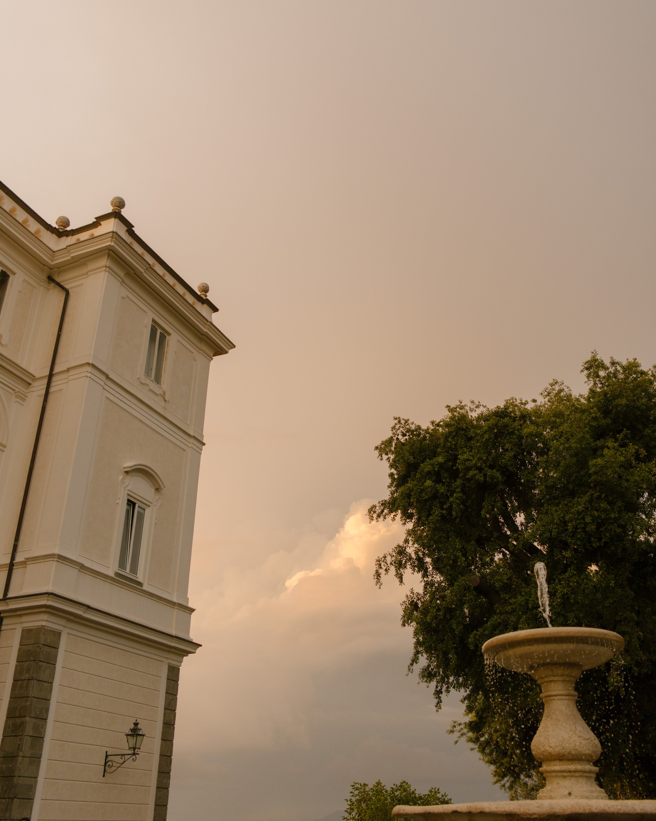 Golden sunset in Italy overlooking buildings and fountain. 