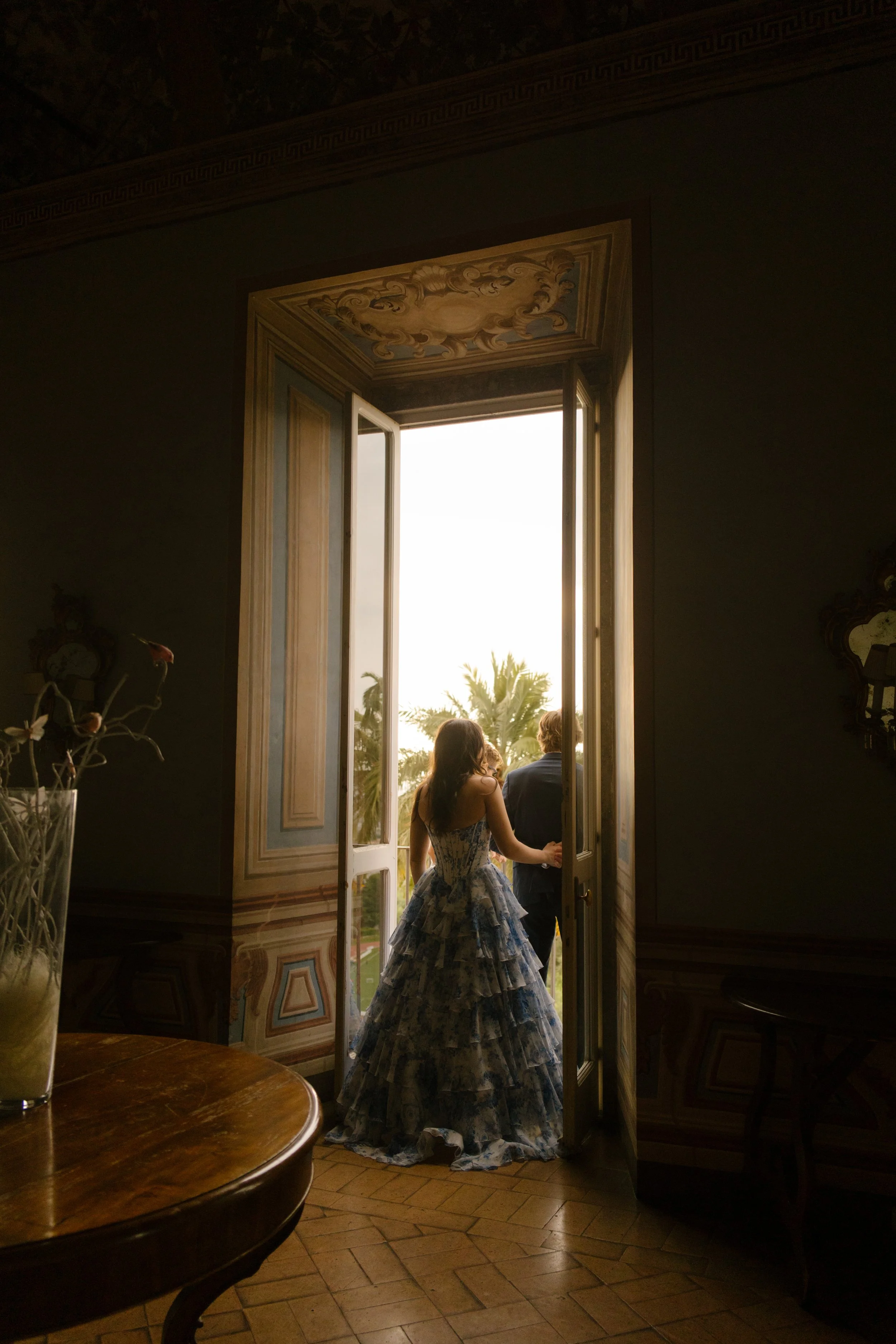 Bride walking out to balcony before wedding rehearsal with family and friends for wedding in Italy.