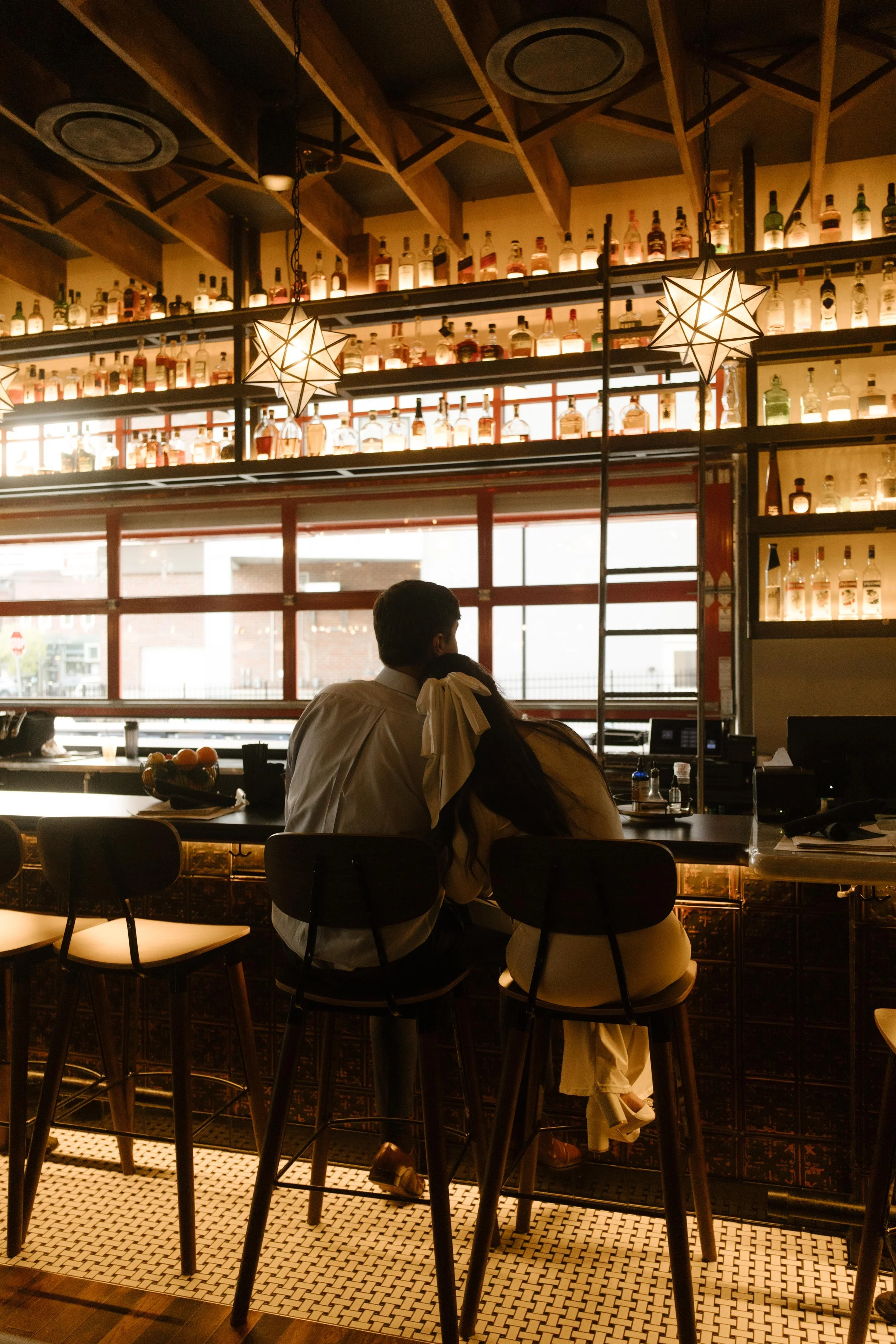 A cozy moment at the bar, the bride rests her head on the groom’s shoulder as they share a quiet toast after their Knoxville courthouse elopement.
