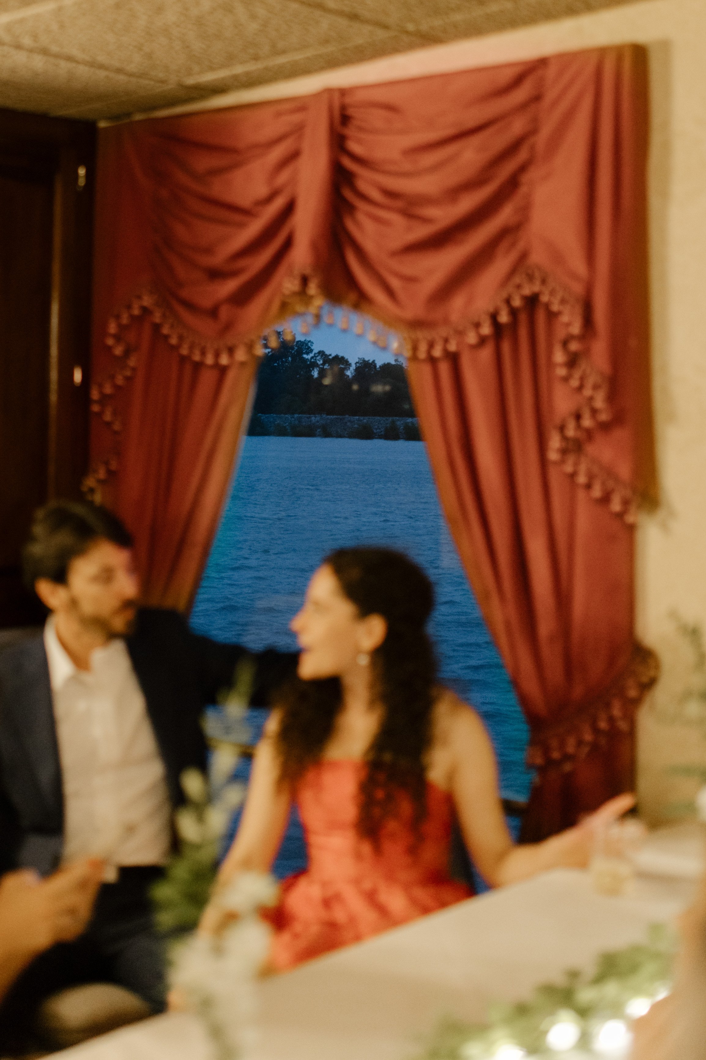 The couple sitting by a window on the Creole Queen, talking as the Mississippi River drifts by—a signature New Orleans wedding moment.