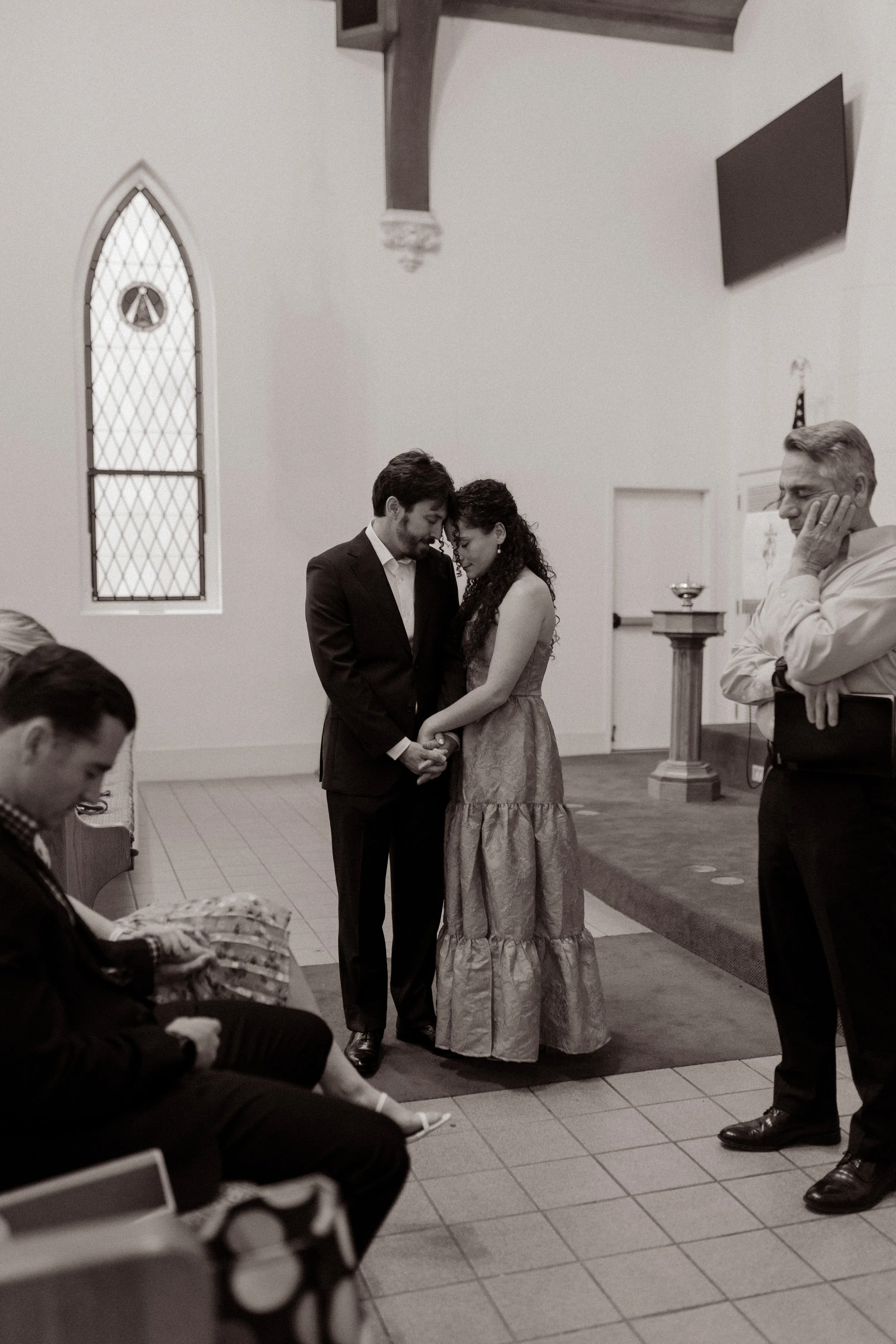 A quiet, emotional pause between the couple during their New Orleans wedding rehearsal, captured in black and white.