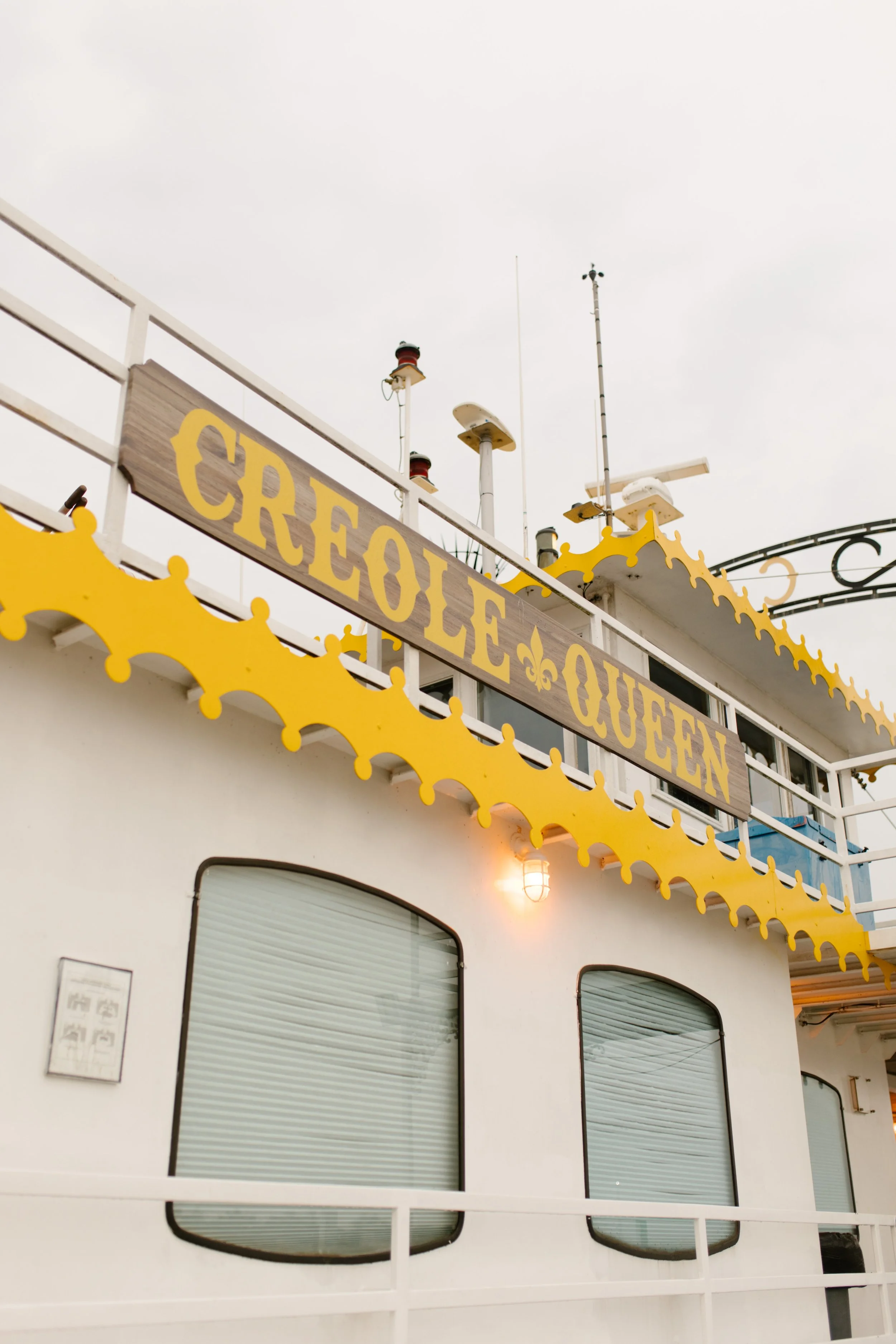 The Creole Queen riverboat’s iconic yellow sign glowing at dusk—an unforgettable New Orleans wedding venue.