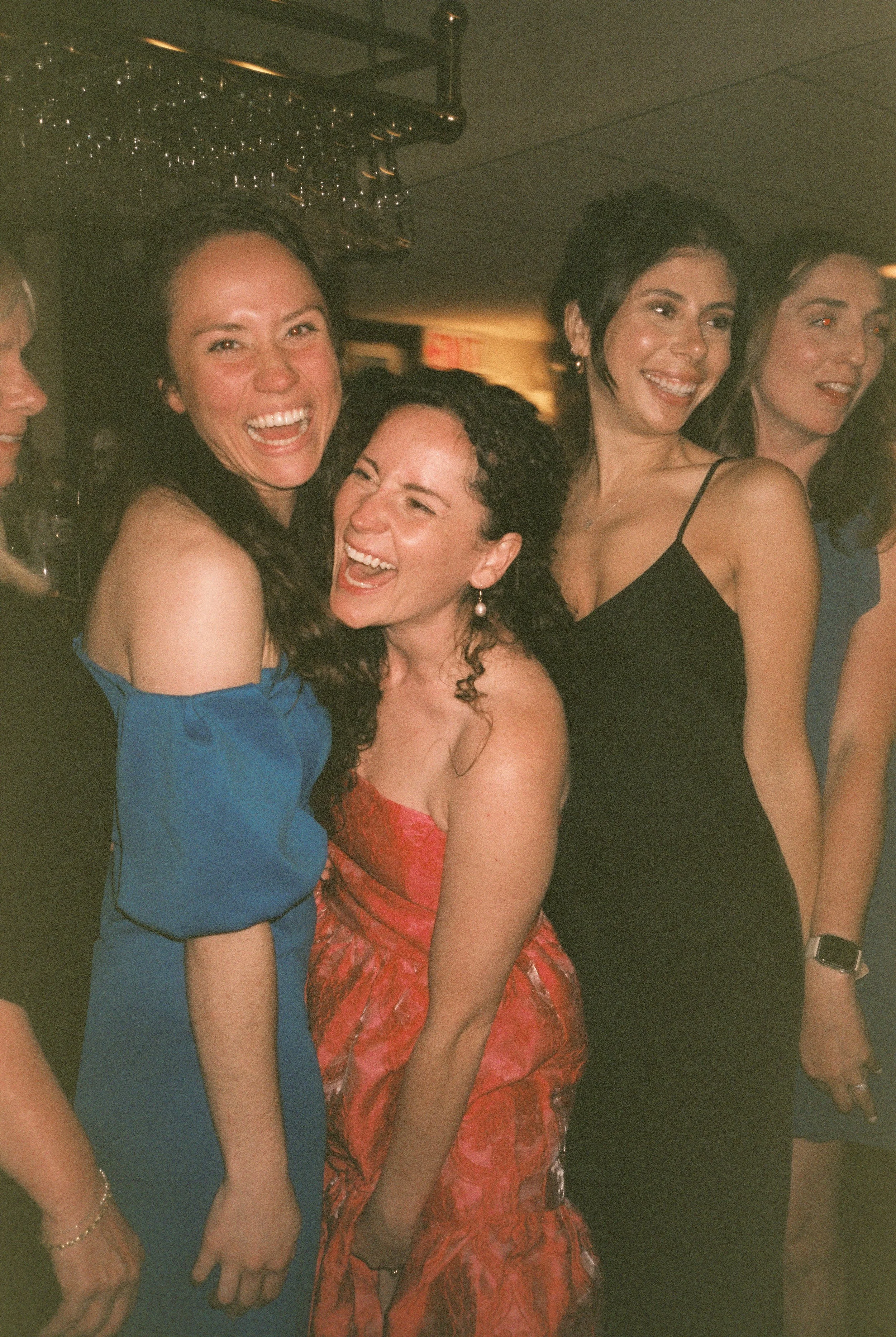 Bride laughing with guests as they gather her in a tight squeeze.