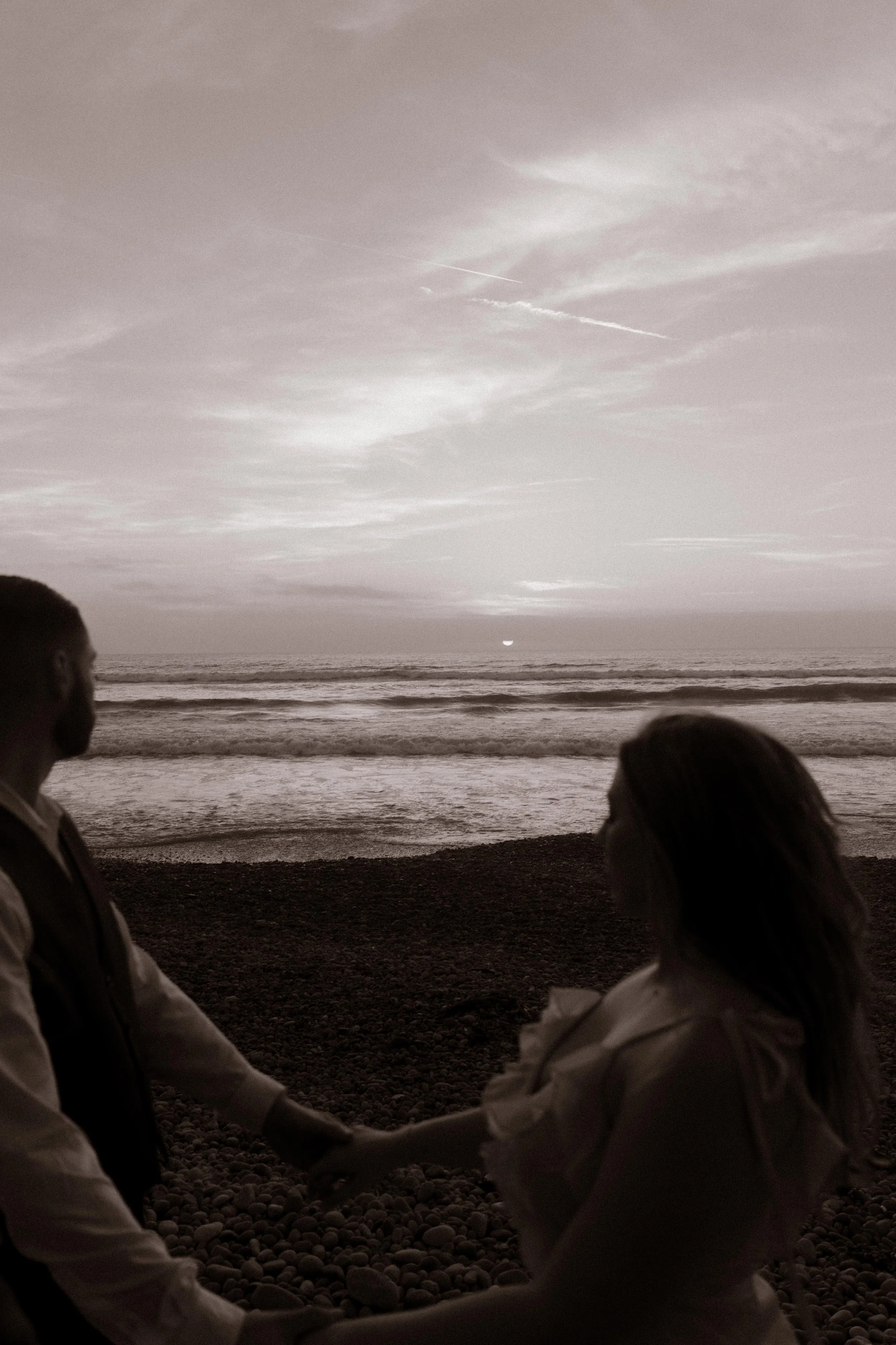A quiet black-and-white moment as the couple watches the sun set over the Pacific — intimate and timeless San Diego engagement photo.